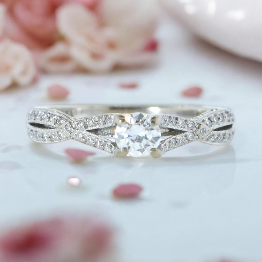 Diamond and 18k gold ring, featuring a brilliant cut diamond, estimated to be near colorless (H/I) and very slightly included (VS2). The center diamond weighs an estimated 0.33 cts., showcasing a white hue. The band is intricately designed with