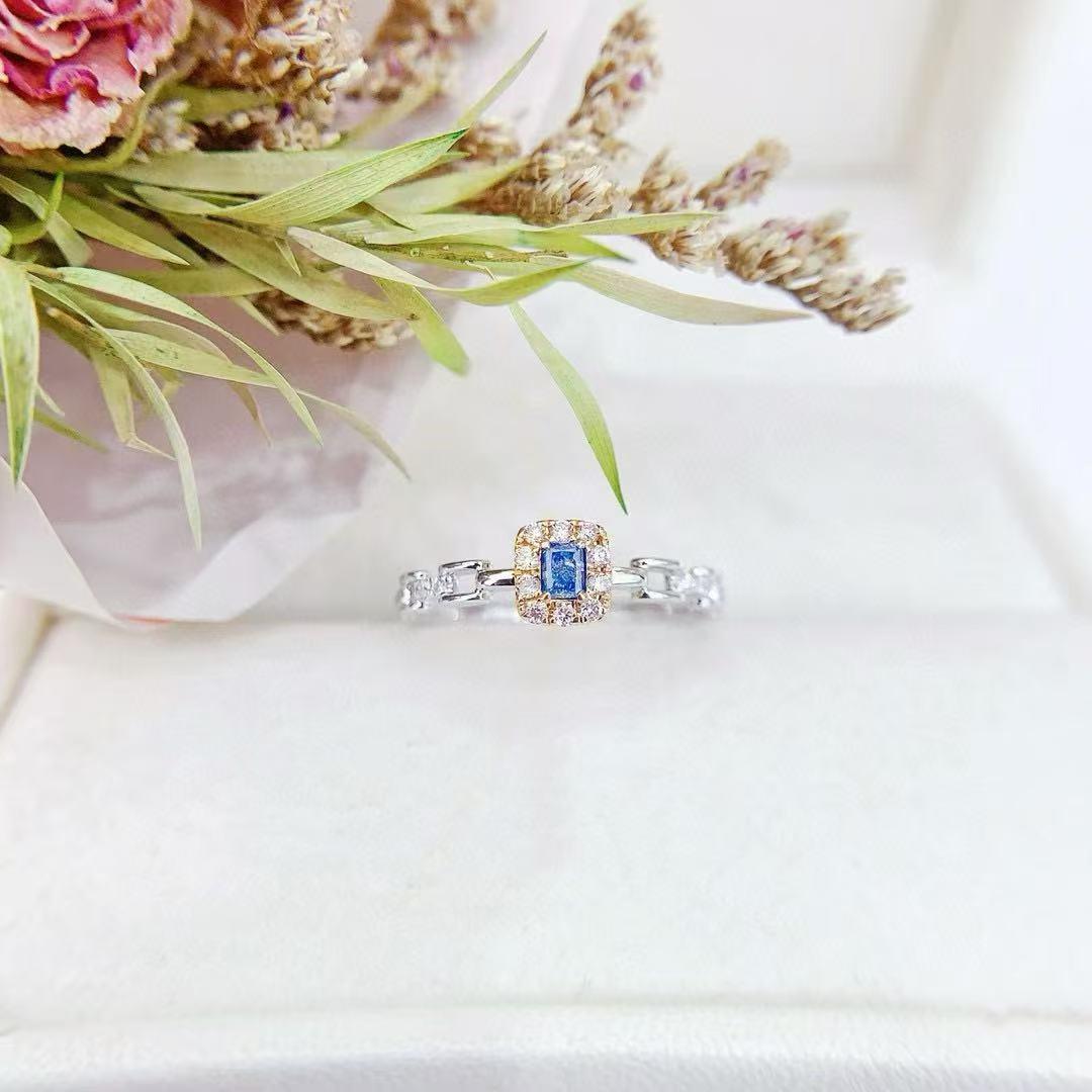 18K Gold Ring Cushion - cut Blue Diamond with Chain Element

Main stone D - 0.09 CT
Side Stone D - 0.10CT 
Total Weight - 3.86 GM

Unique Centerpiece: A vivid, rectangular - cut blue diamond at the core, exuding elegance.
Charming Halo: Surrounded