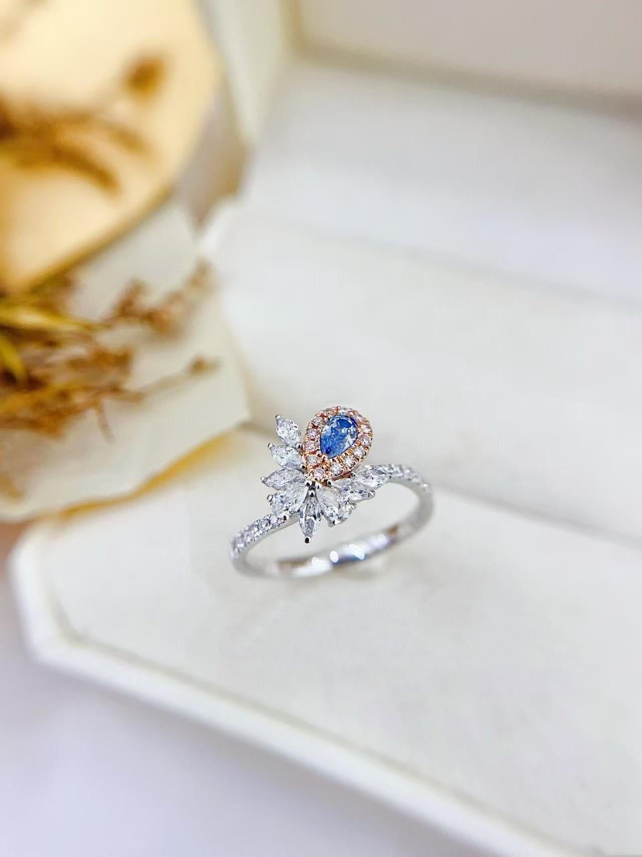 Bague en or 18 carats à tige torsadée irrégulière avec diamant bleu en forme de larme

Pierre principale D - 0.17 CT
Pierre latérale D - 0,54 CT 
Poids total - 2,53 GM

Une pièce maîtresse étonnante : Un diamant bleu en forme de goutte d'eau vole la