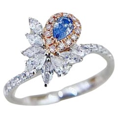 Anello in oro 18K con gambo ritorto irregolare e diamante blu a goccia