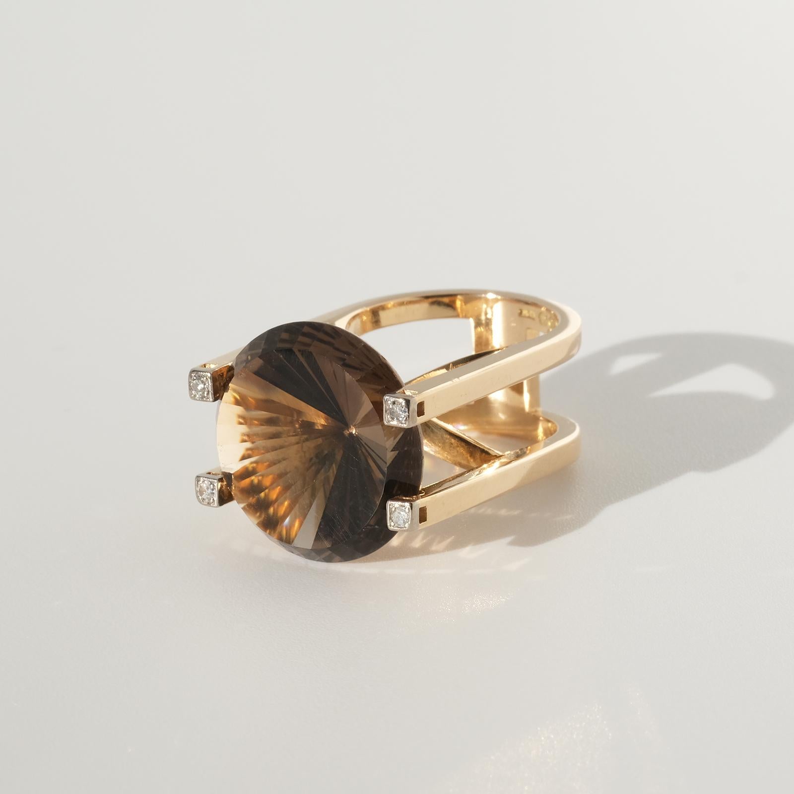 This luxurious 18 karat gold, smoky quartz and diamond ring has an exquisite design with its high shaped setting and its big mixed cut smoky quartz. The final touch is the four octagon cut diamonds.

This ring is perfect for the cocktail party and