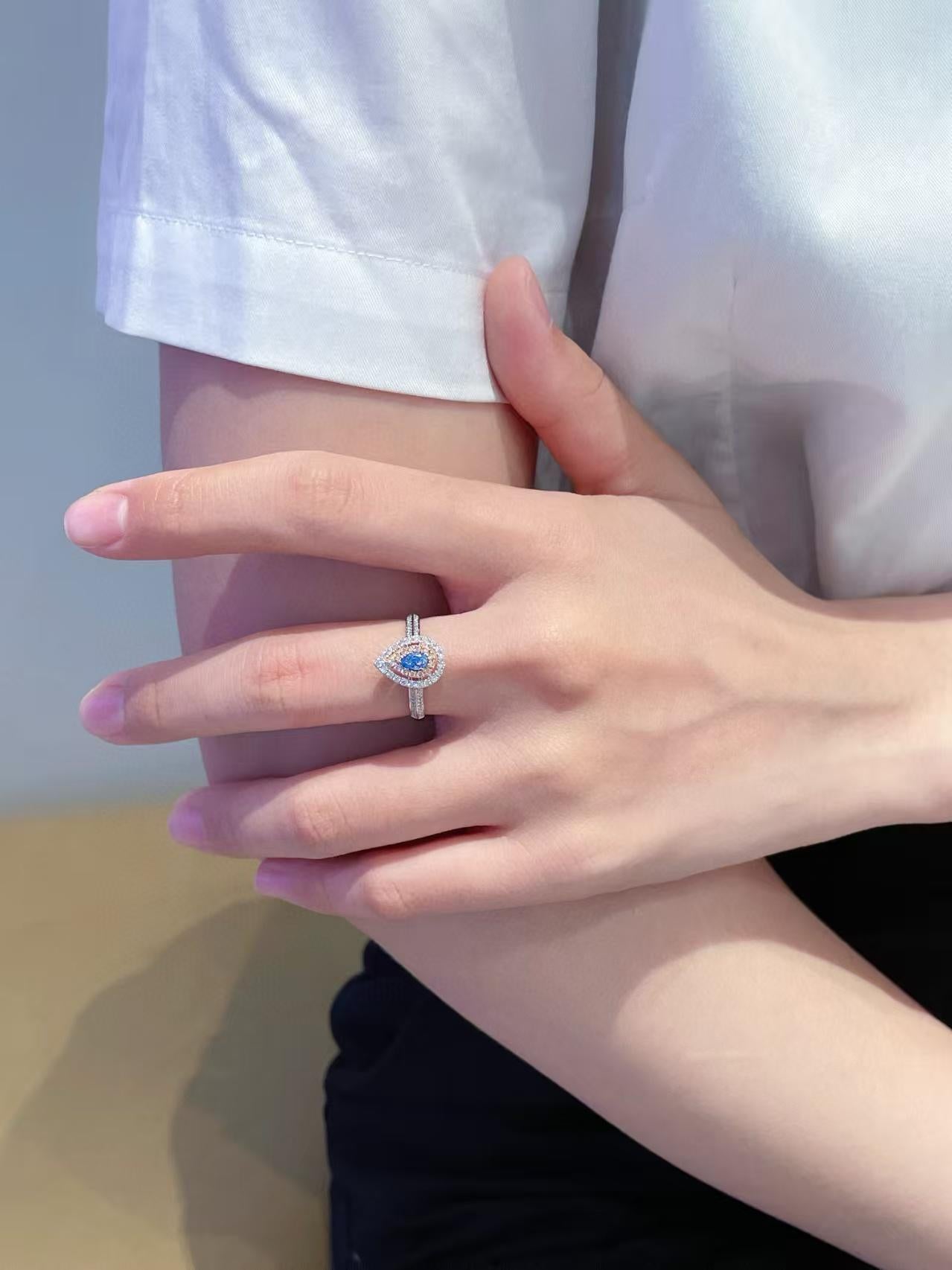 Modern 18K Gold Ring Rare Teardrop Cut Blue Diamond Encircled by Dazzling Halo For Sale