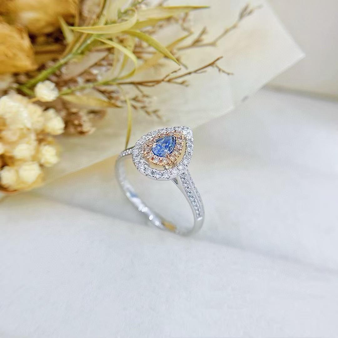 Pear Cut 18K Gold Ring Rare Teardrop Cut Blue Diamond Encircled by Dazzling Halo For Sale