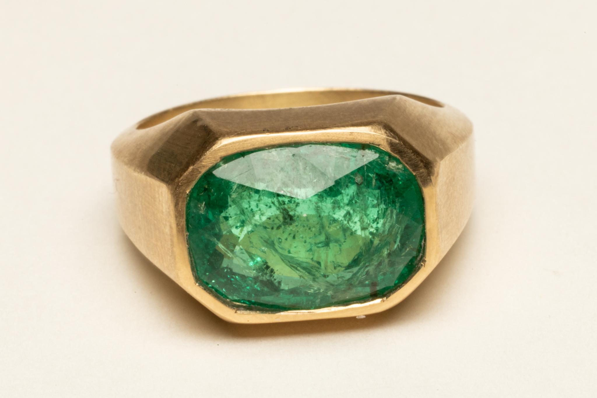 Uno splendido smeraldo sfaccettato da 5 carati incastonato in una fascia d'oro 18 carati smussata.  La misura dell'anello è una 7.  Classico ed elegante.

La collezione di alta gioielleria è stata acquistata, disegnata o creata da Deborah Lockhart