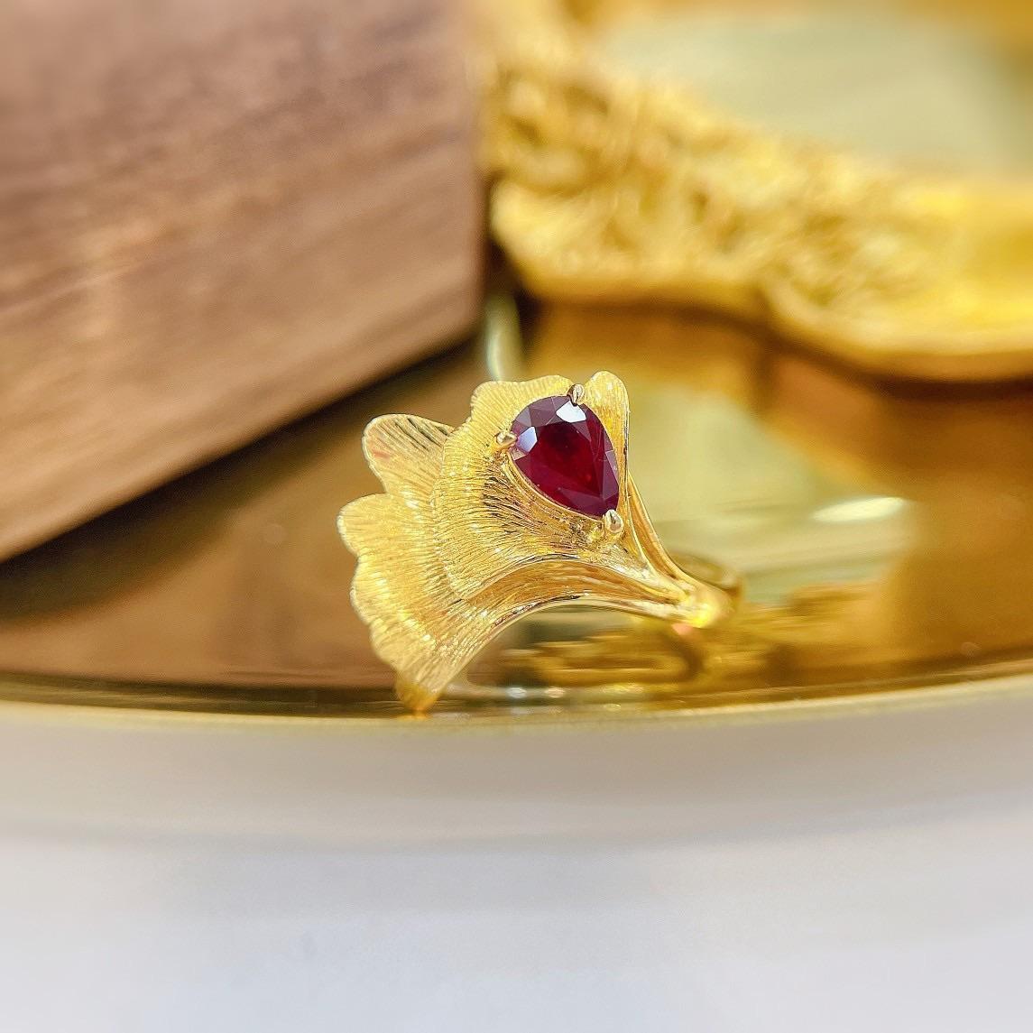 Cette bague en or 18 carats est ornée d'un rubis naturel de 0,53 carat, taillé en poire, rehaussé de 0,09 carat de diamants naturels rayonnants. La forme poire, connue pour son élégance en forme de goutte d'eau, incarne la sophistication et le
