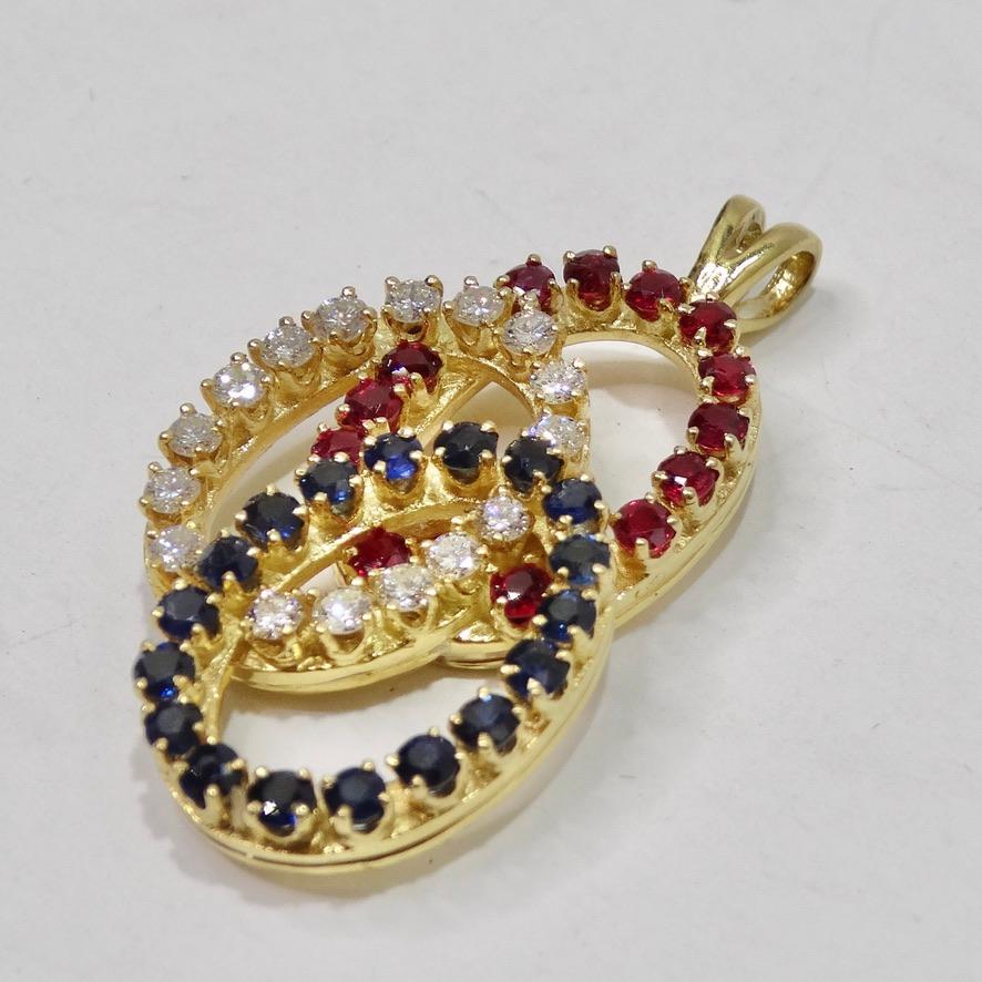Do not miss out on this breath taking 18 karat yellow gold interlocking oval pendant circa 1980s. One of the circles contains 18 faceted round cut sapphires, measuring approximately 0.07ct each, weighing approximately 1.26TW (Total Weight). The