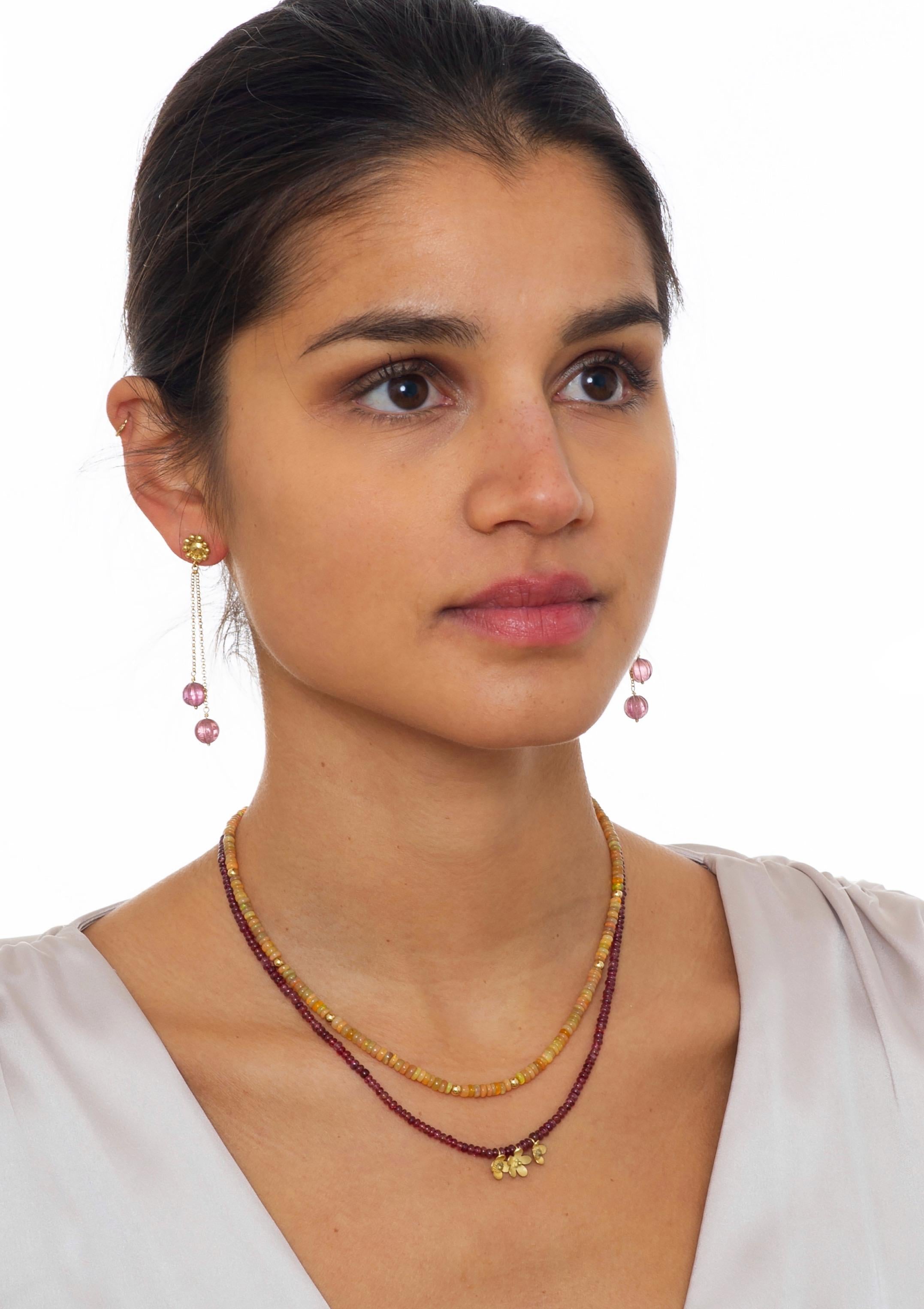18k Gold short necklace of smooth pink spinel beads and handmade dainty little gold flower charms. 
A versatile and colourful addition to any jewelry wardrobe in any season. The shorter length makes it a great option for stacking with other styles.
