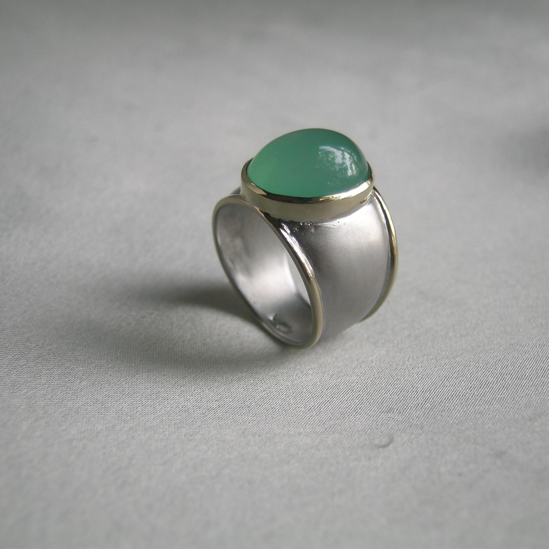 Nancy has  applied her signature satin finish onto Silver, making a fresh, unique and fun look meant to be worn every day.  The ring looks expensive, but is not!  The 9 carat Cabochon Chrysophrase is the color of the Caribbean Sea and anyone who