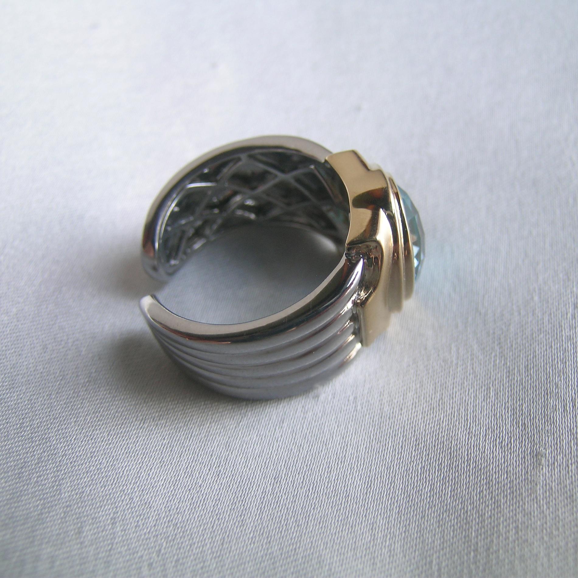 Une belle bague unisexe combinant l'or et l'argent pour une bague unique et audacieuse avec une magnifique topaze bleue comme point central.  Très confortable, très facile à porter.  Un luxe quotidien assuré par la finition satinée caractéristique