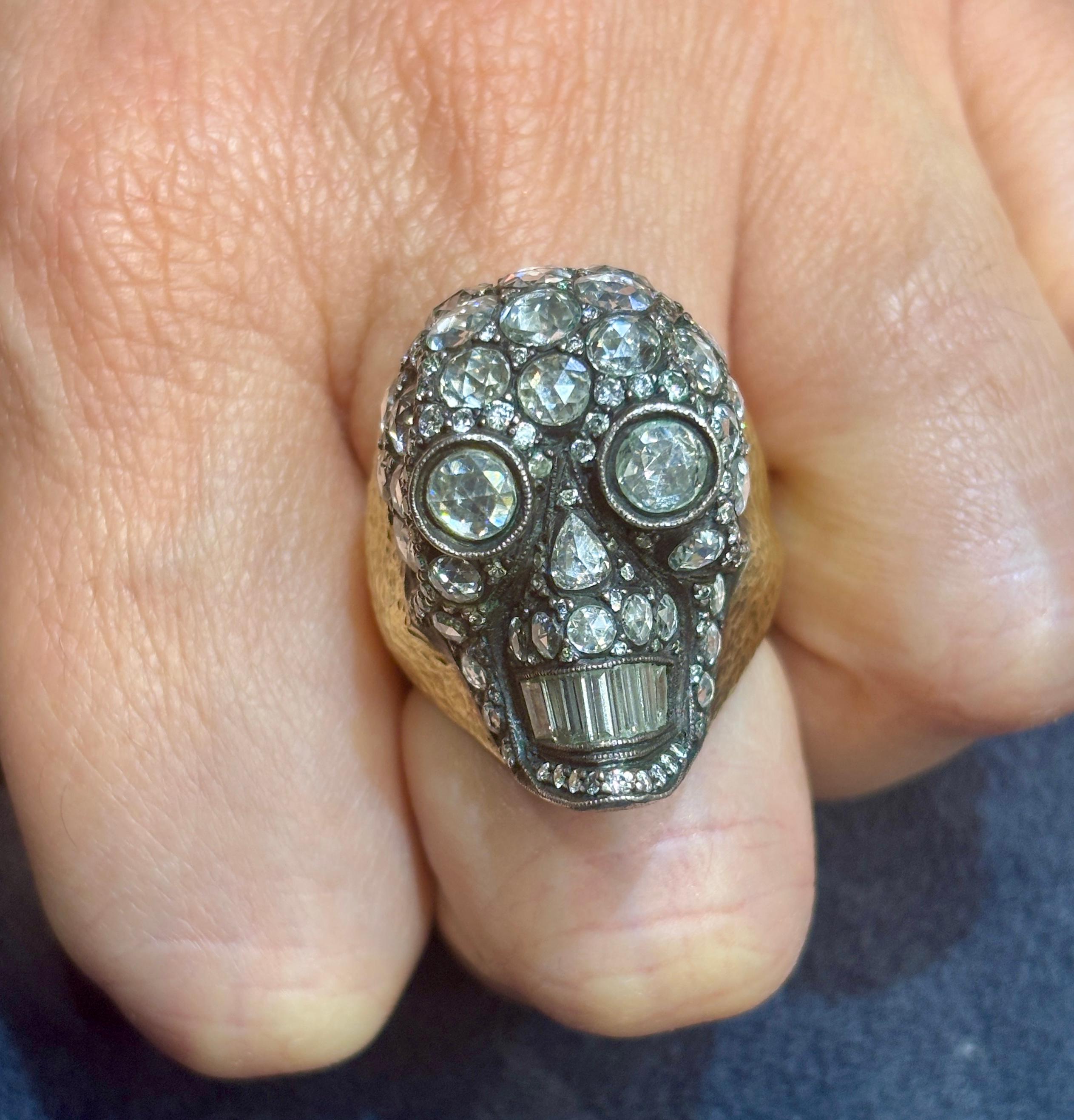 Questo anello in oro e argento 18k del 1990 ha la forma di un teschio ed è ornato da circa 5 carati di diamanti, la maggior parte dei quali con taglio a rosa e baguette. È un pezzo davvero insolito.
