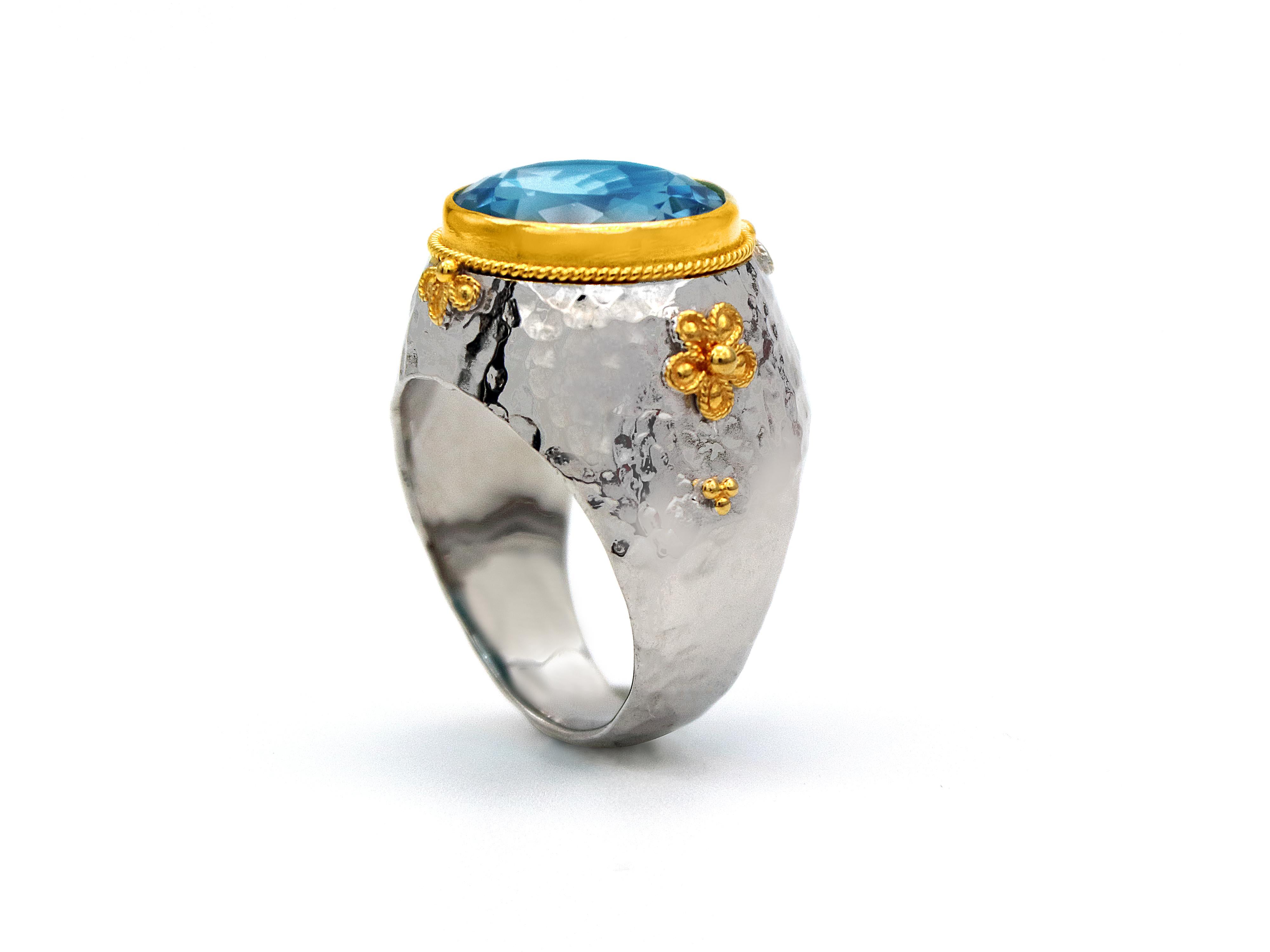 A mix and match of metals and colors. Sterling silver base, hummer worked and decorated with 18 karat yellow gold. Set with Baby Blue Topaz in a around briolette cut that the multi facets play so strong with the light and show its amazing color. The