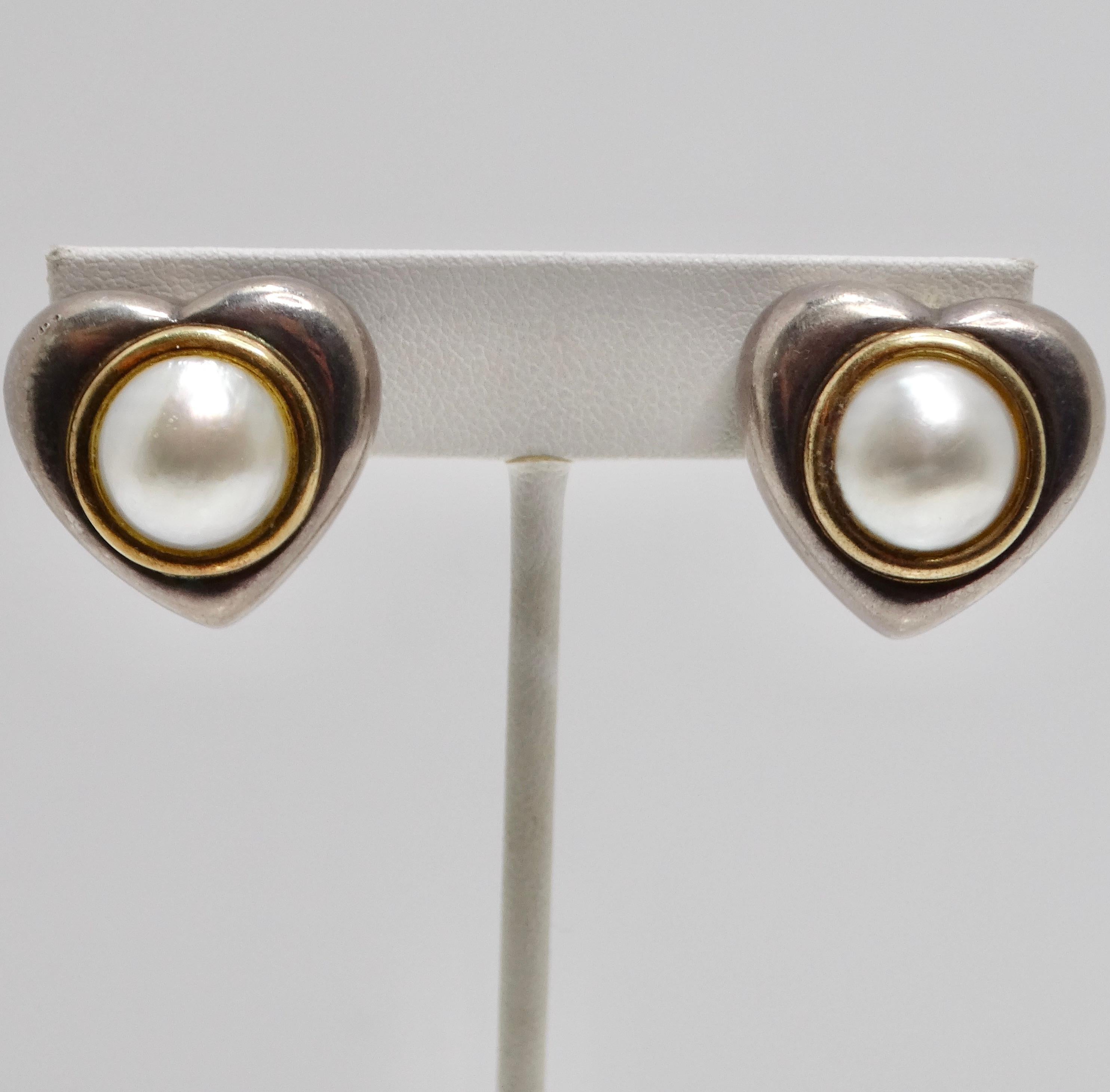 Introducing the exquisite 1960s 18K Gold Silver Pearl Heart Earrings, a beautiful vintage accessory that exudes timeless elegance and romance. Crafted in the 1960s, these heart-shaped earrings feature a luxurious silver base adorned with stunning