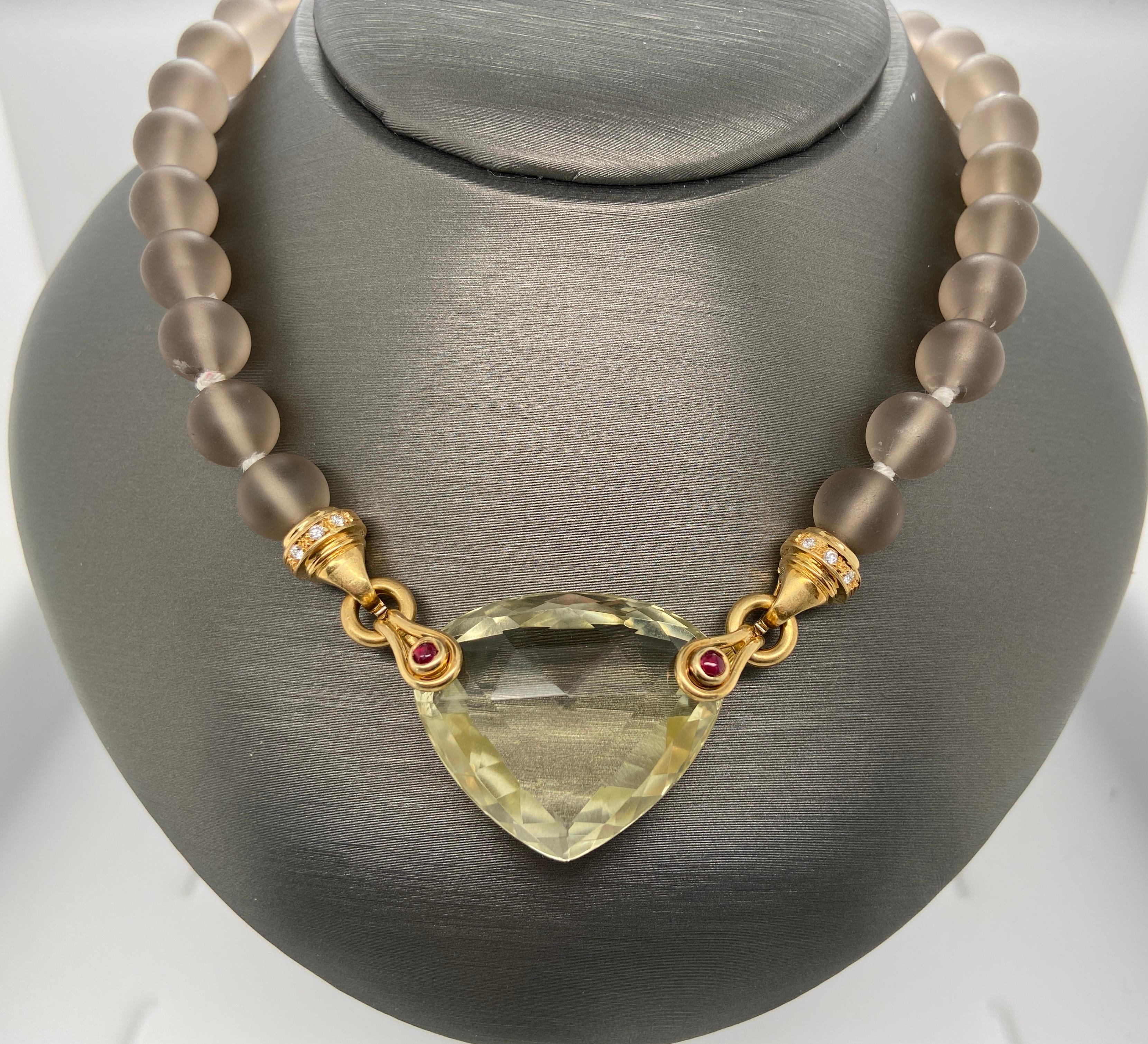 This incredible necklace is exceptional in its make and composition. At the center of the necklace is a citrine weighing approximately 60cts, mounted on each side with stirrup-shaped gold, accented on each side by cabochon-cut, bezel-set rubies