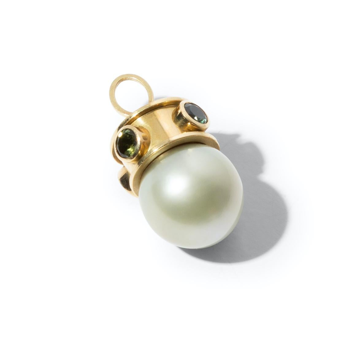 Unique 18k gold pendant with a large silver grey Tahiti pearl and four sapphires in tonal shades of green. An intriguing combination of shape and colour, pearl and gemstone. Wear it on a short or long necklace to add some mystique to your