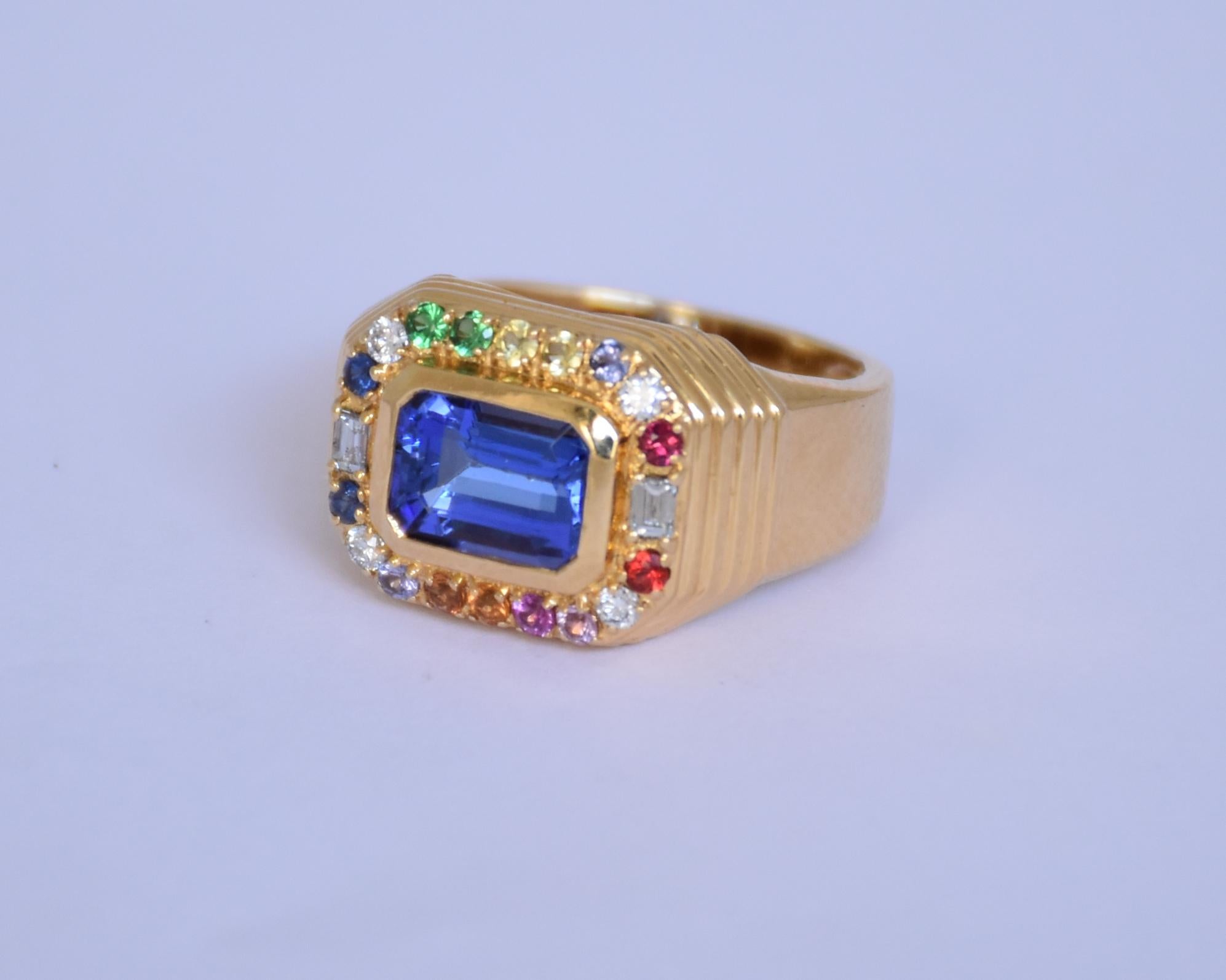 Anello in tanzanite (pietra titanica) a 18 carati dal design unisex. La tanzanite ottagonale centrale è pulita con una dimensione di 2,03ct, il pezzo è accompagnato da zaffiri e diamanti naturali. I diamanti sono di colore J e K con una purezza VS.