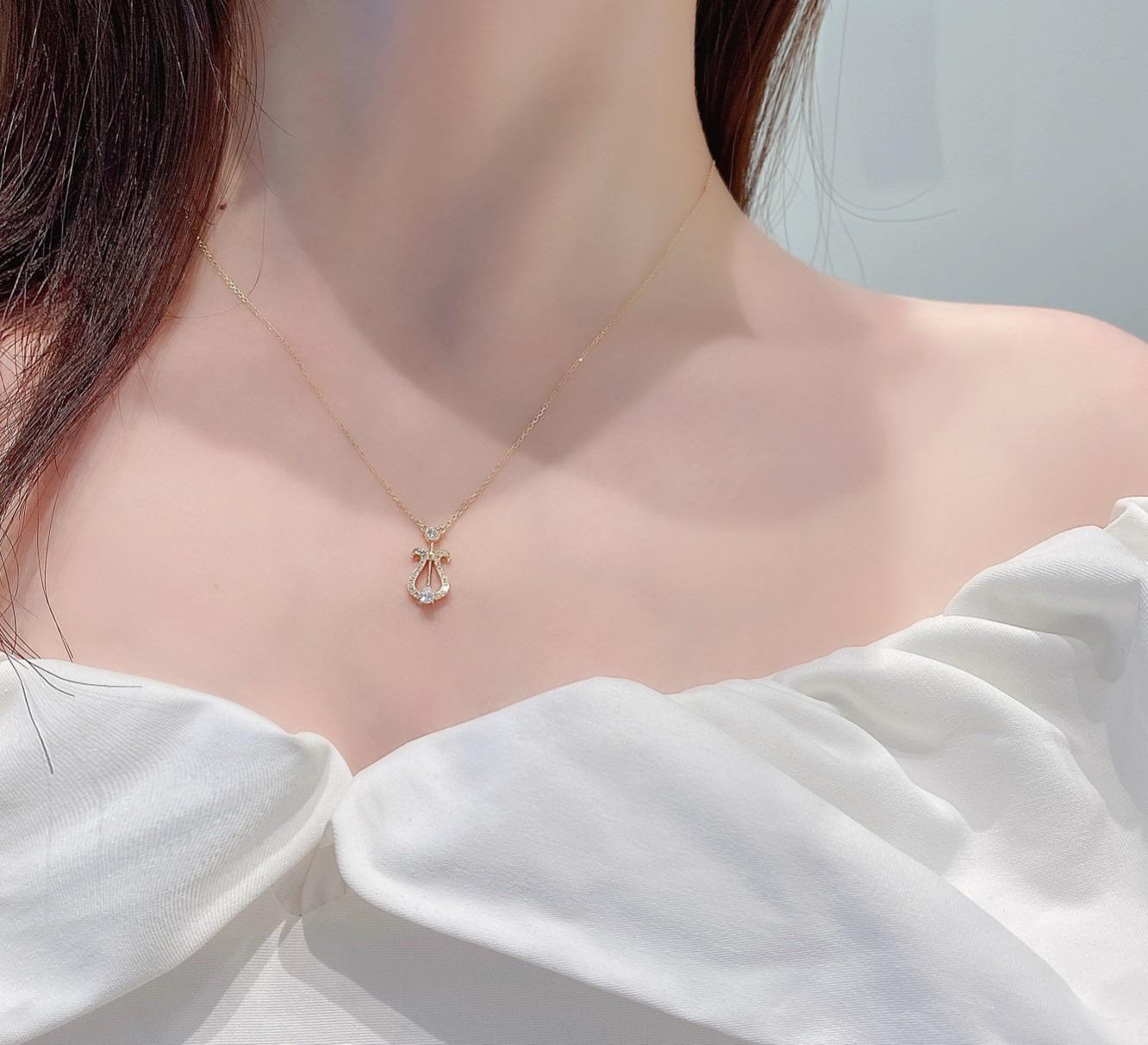 Light as a melody and crafted with lyrical grace, this 18K gold pendant necklace takes inspiration from the elegant curves of a lyre. A delicate teardrop-shaped diamond (0.07ct) rests at its heart, encircled by a shimmering constellation of diamonds