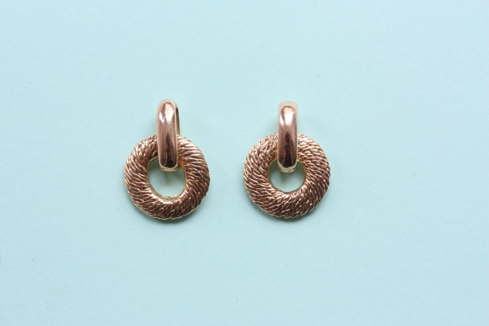A pair of 18 carat gold earrings with a woven textured disc held by a polished straight ring (most likely an element from a Georges Lenfant chain or bracelet).

weight: 8.83 grams
dimensions: 19.8 x 14 mm