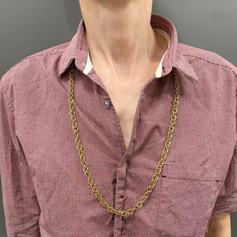 An 18k gold twisted link chain necklace, French made.  Each link is formed by a small ring threading through and around a group of coil-like rings. This design creates a layered look and a woven appearance.  When worn long, it falls just below the