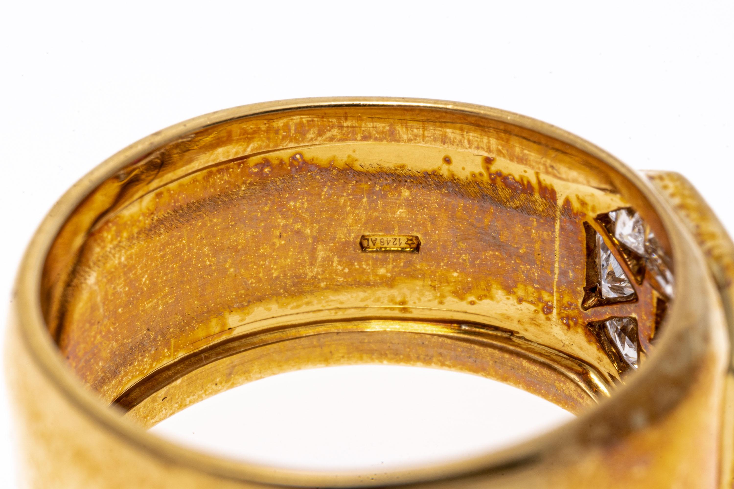 bague en or jaune 18k. Cette spectaculaire bague en or jaune ultra large est un anneau, serti sur le dessus d'un rubis central carré à facettes, de couleur rouge, d'environ 0,20 CTS, serti sur barre, et encadré par un halo de diamants alternés de