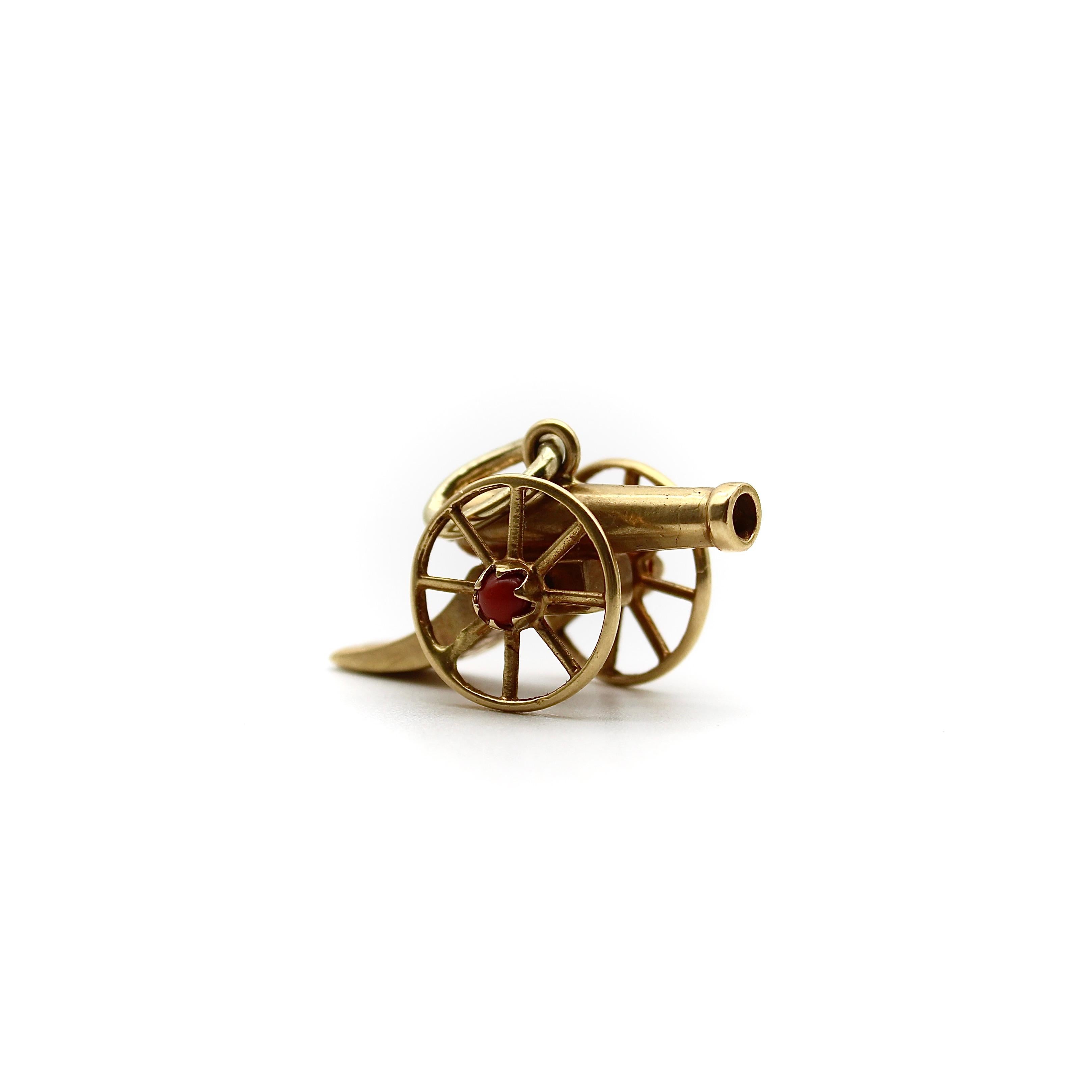 Questo ciondolo vittoriano in oro 18k ha la forma di un cannone, con parti mobili articolate che permettono alle ruote di girare. Il ciondolo presenta dettagli intricati, incisi con delicate foglie di foglia sia sulla parte superiore che inferiore