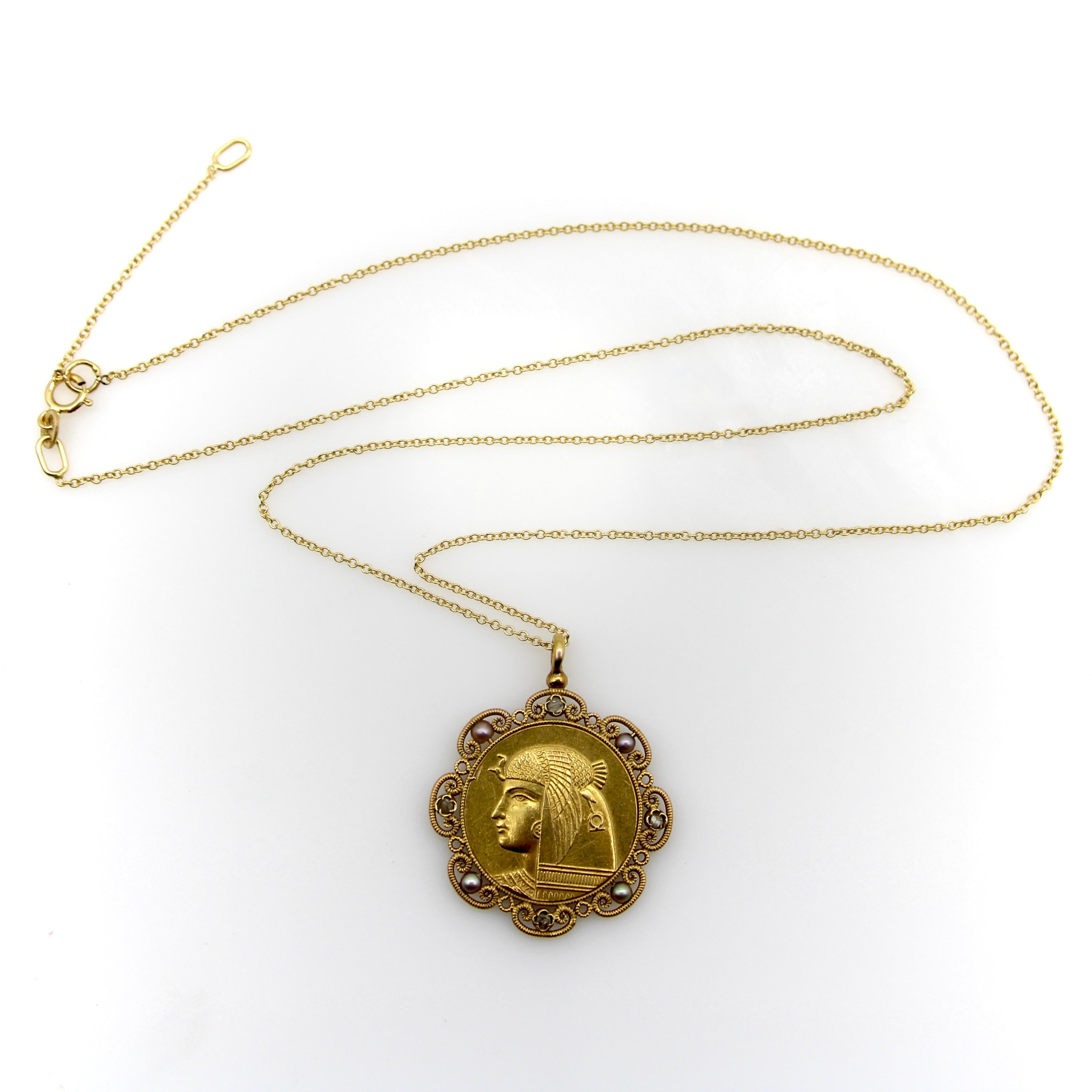 This 18k gold two-sided French Victorian Egyptian Revival pendant necklace features the portrait of the goddess Nekhbet, surrounded by a lace-like halo of pearls and Rose Cut diamonds. Circa the 1880’s, the portrait is exquisite and the detail is