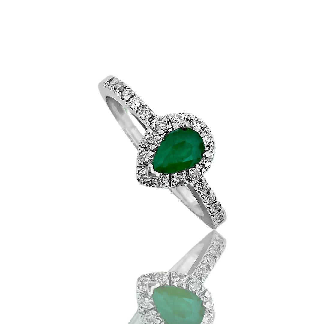 Introducing this beautiful vintage ladies diamond and emerald ring, crafted from luxurious 18k white gold. Adorning the ring are 0.24 carats of round brilliant cut diamonds, boasting VS2-SI clarity and G color, adding sparkle and elegance. The
