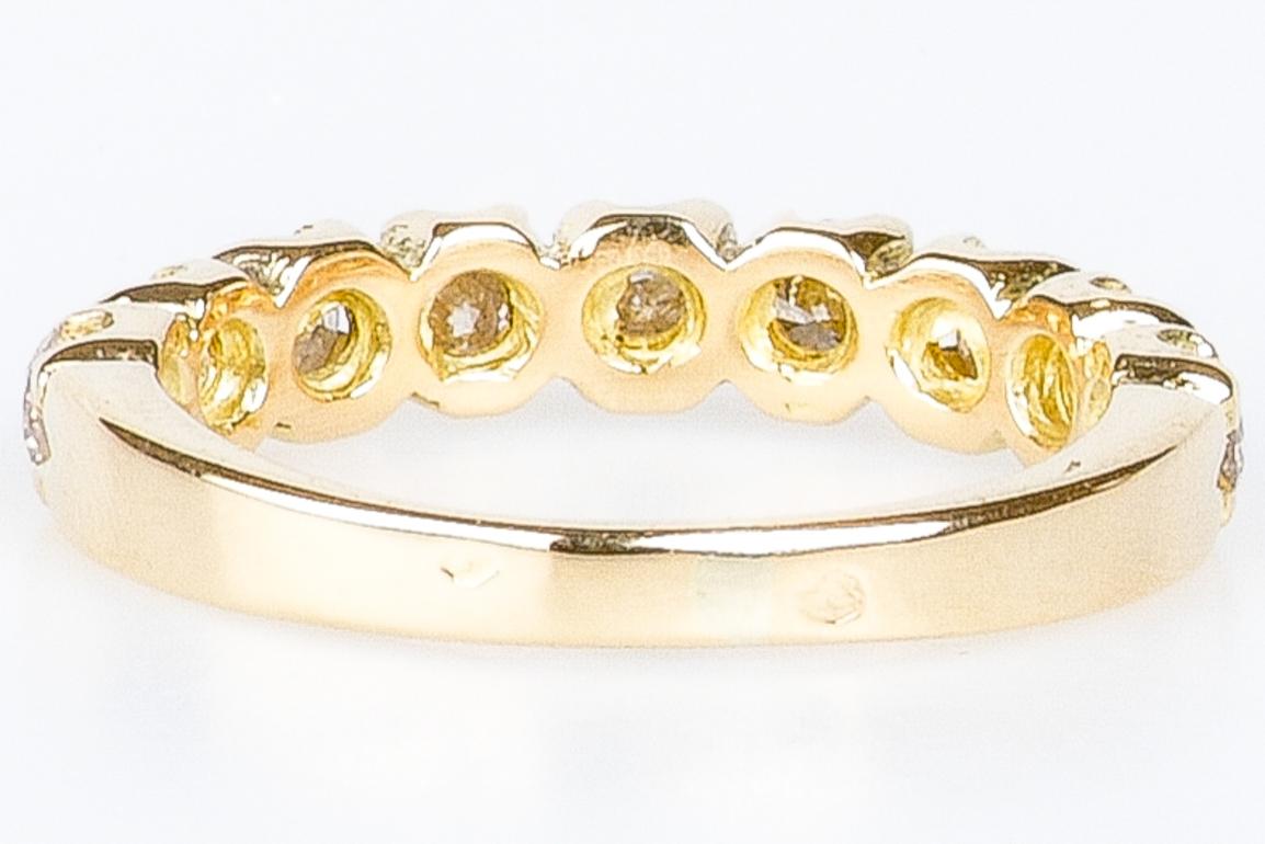 Dieser Ehering aus 18 Karat Gold ist ein Symbol für Verbundenheit und zeitlose Schönheit. Er ist mit neun wunderschönen Diamanten von je 0,10 Karat, also insgesamt 0,9 Karat, verziert. Die Diamanten sind sorgfältig entlang des Rings angeordnet und
