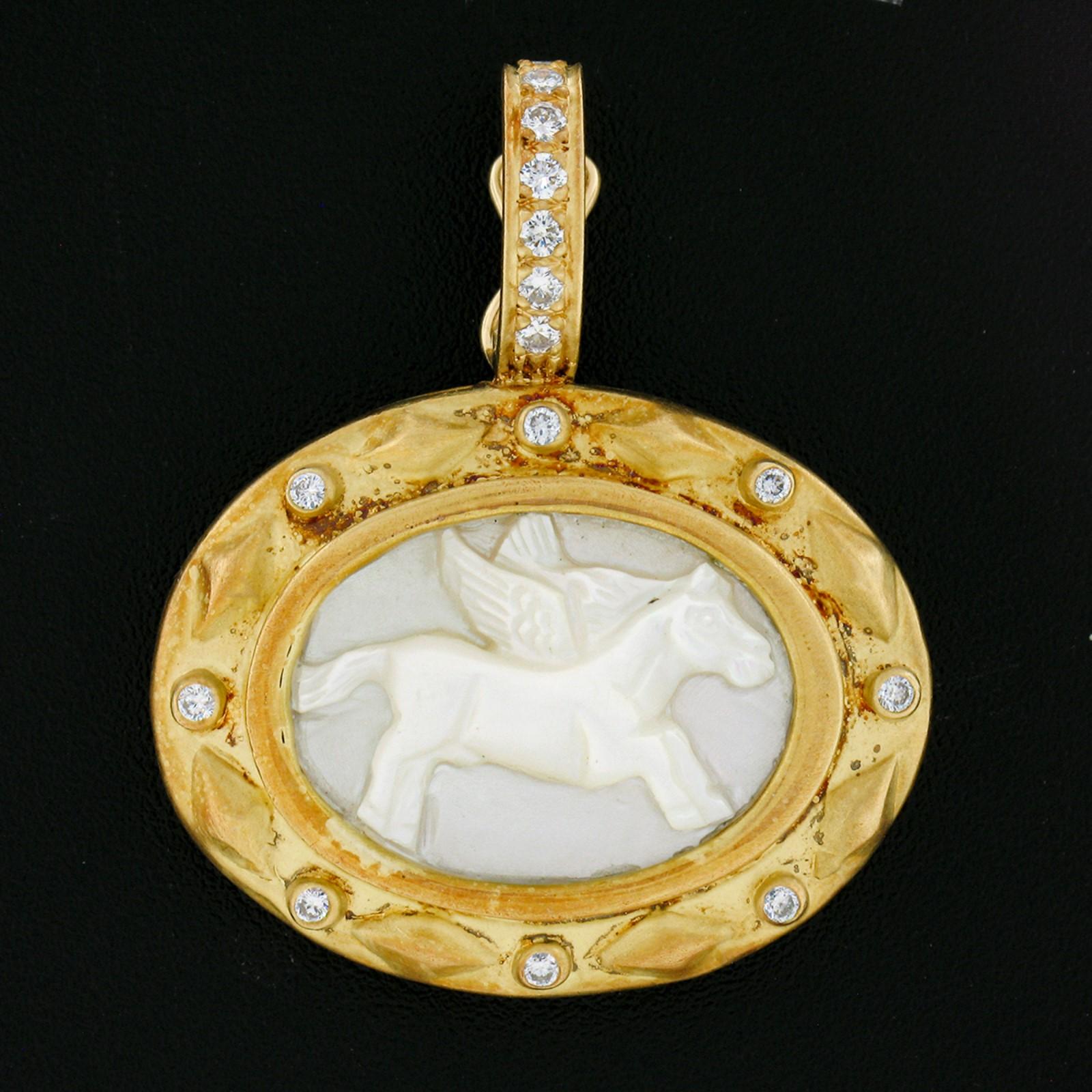 This wonderful enhancer pendant is crafted from solid 18k yellow gold and features a genuine mother of pearl stone that has been masterfully carved into showing a lovely and detailed winged horse at its center. The oval mother of pearl is neatly