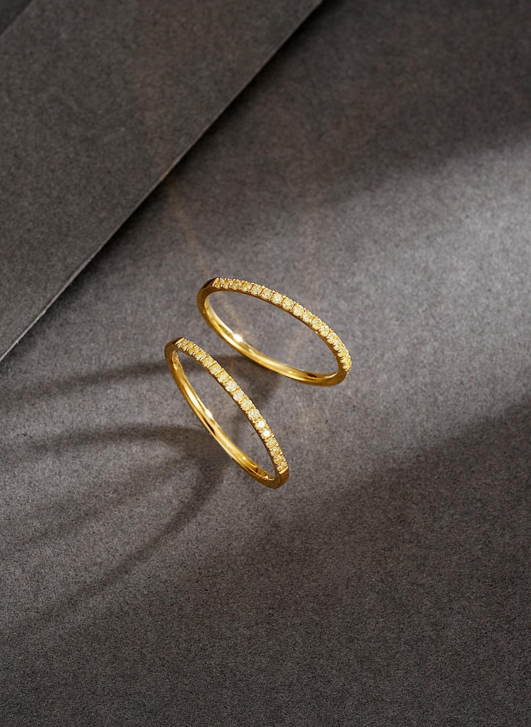 Simple yet captivating, this 18K yellow gold band ring features a natural yellow diamond of 0.12ct, carefully set to enhance its vibrant glow. The minimalistic design allows for effortless styling, whether worn alone or stacked with other rings. The
