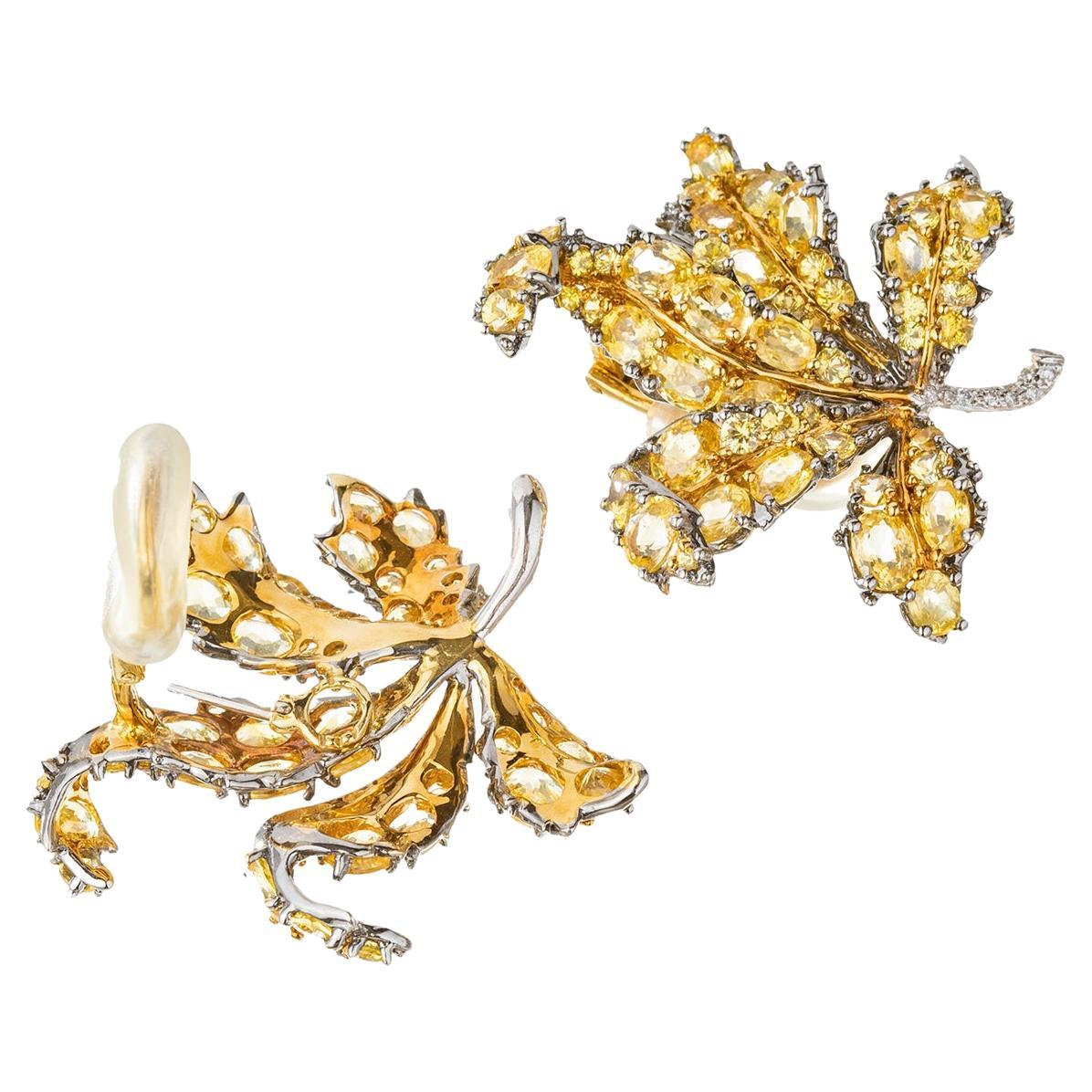 Yellow sapphire leaf earrings in 18k yellow, white and blackened gold with a diamond-set stem.  Oval and round faceted yellow sapphires weighing approximately 15 total carats. Twenty round brilliant-cut diamonds set at the stem of each.  Clip backs