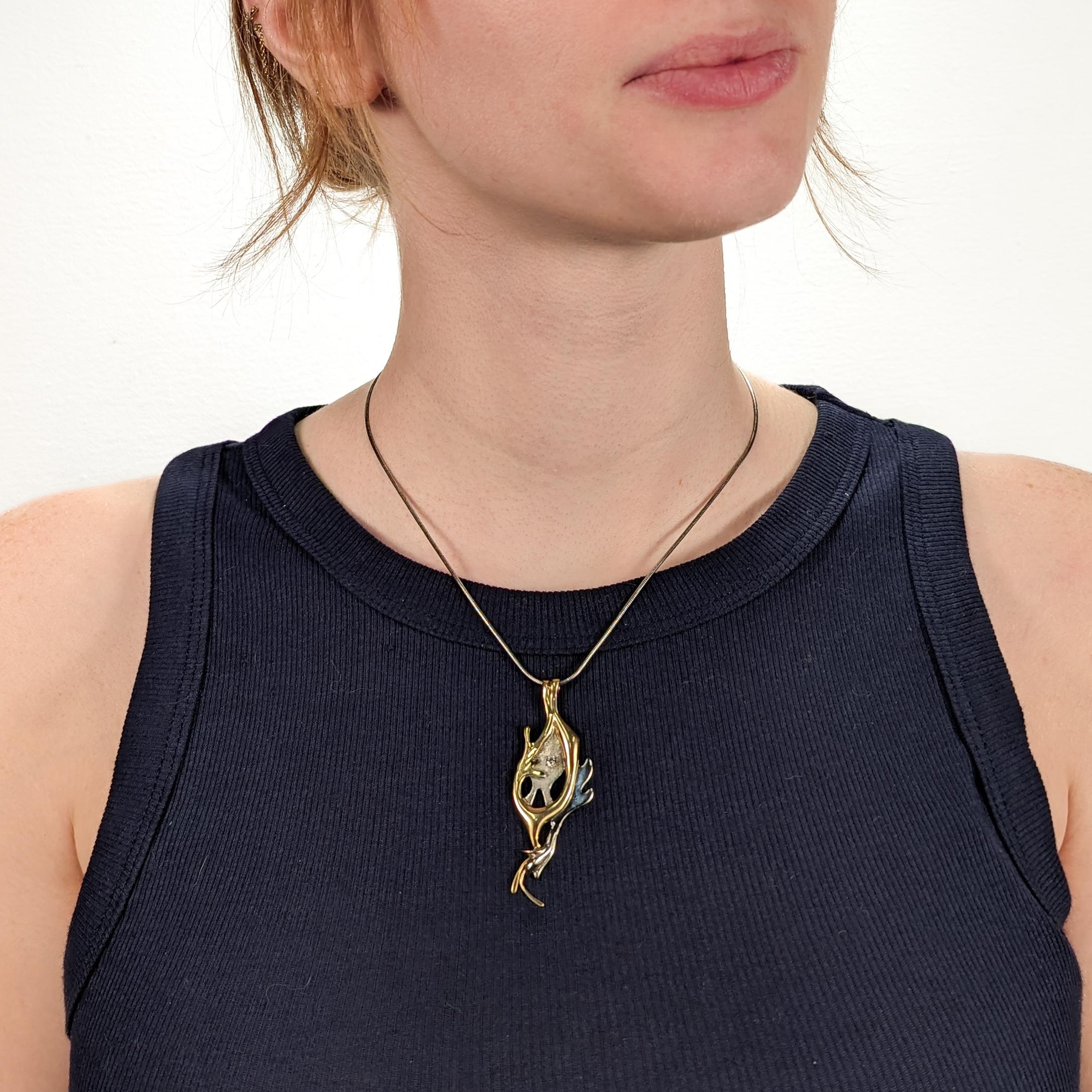 A fine handmade pendant for a necklace.

By the Quebecian jeweler - Geneviève Bertrand.

In green and white 18 karat gold and set with a .10 carat brilliant round cut brilliant diamond.

An abstract, organic modern depiction of the relationship of
