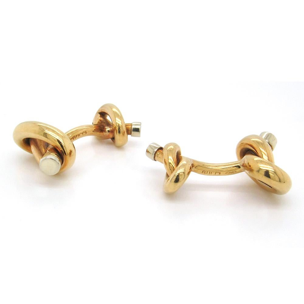 18K yellow gold knotted pretzel-style cufflinks made in Italy by Gucci, measuring 1-1/2″ at the widest x 1-1/8″ long, with white gold tipped ends.