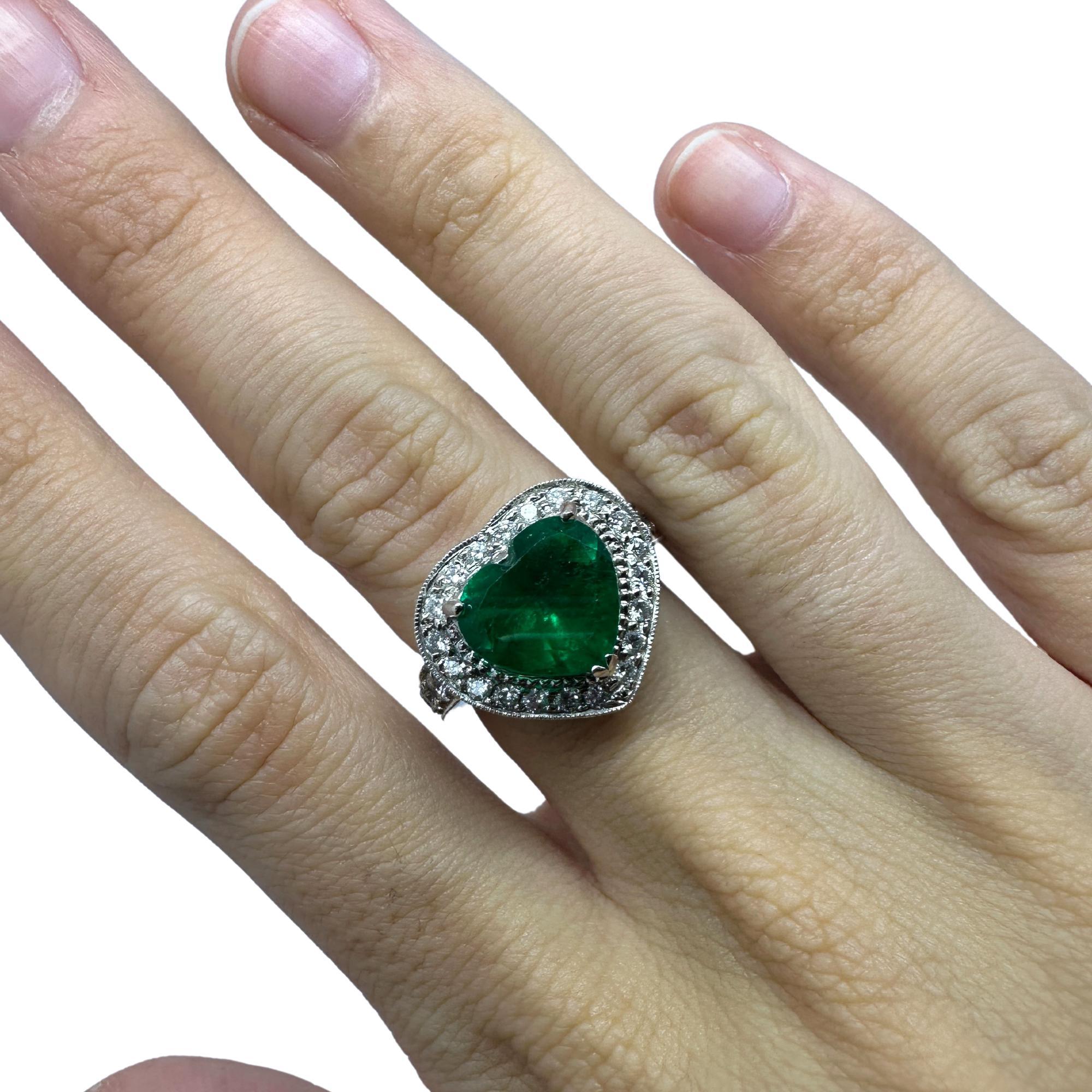 Indulge in the ultimate expression of love with our 18k white gold Heart Shaped Diamond and Emerald Ring.

Weighing 10.7 carats and featuring a stunning 3.63 carat heart-shaped emerald at its center, this ring exudes luxury and sophistication.