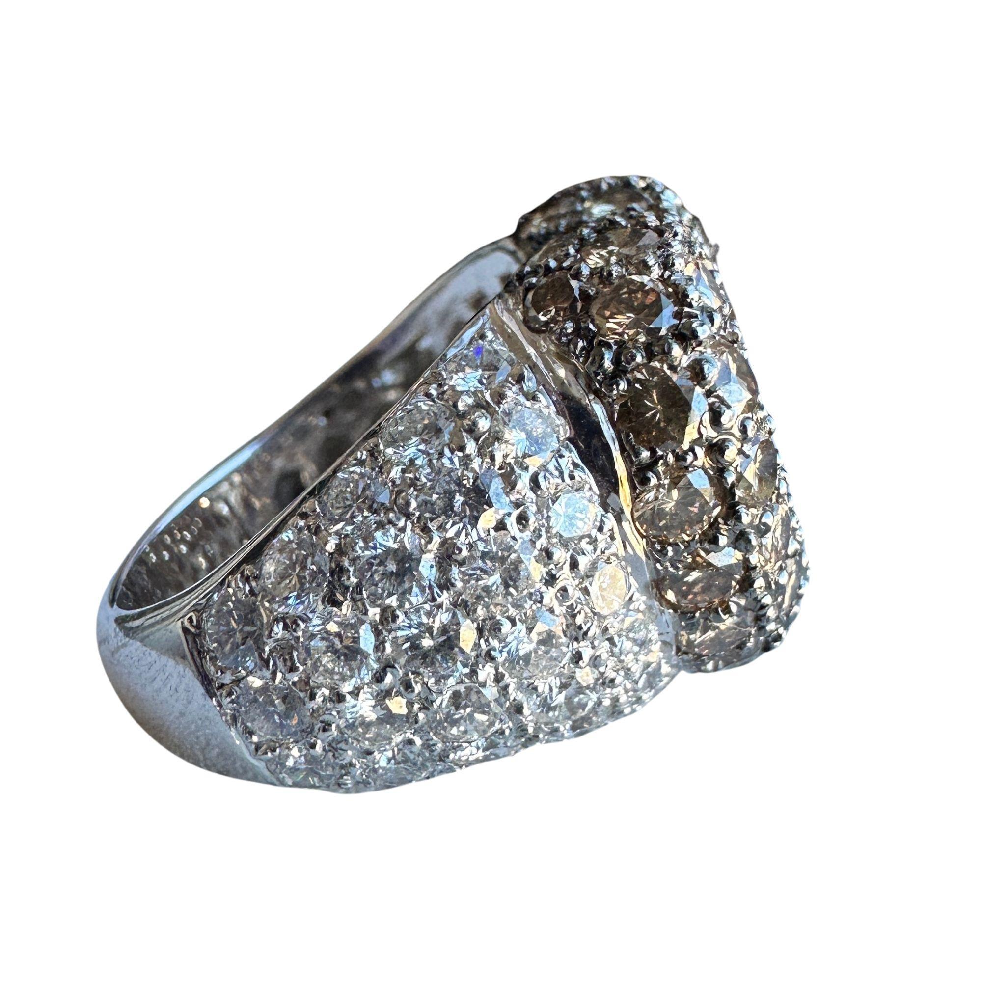 Gönnen Sie sich diesen exquisiten, herzförmigen, weißen und braunen Diamantring in 18 Karat mit einem Gesamtgewicht von 6,3 Gramm und Ringgröße 6,25. Der atemberaubende zentrale Diamant von 0,69 Karat ist von 3,05 Karat funkelnden braunen Diamanten