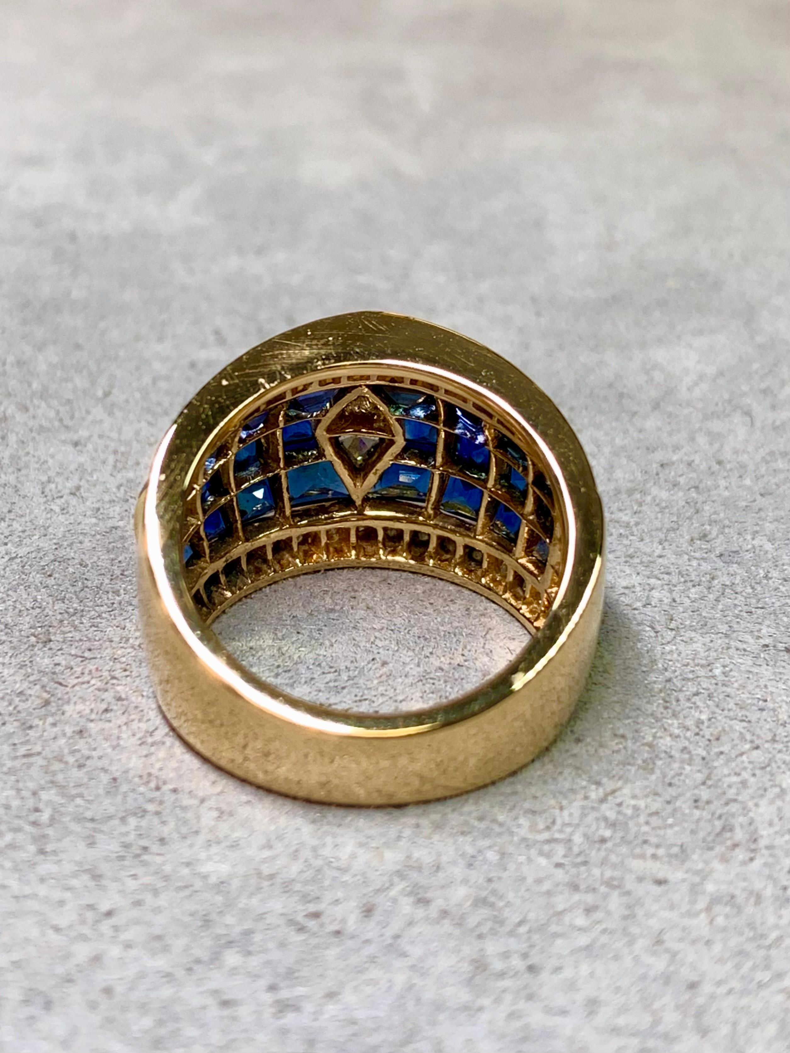 
Dieser außergewöhnliche breite Cocktailring ist ein meisterhaftes Beispiel für eine unsichtbare Fassung und ein kühnes Design. Die aus 18-karätigem Gelbgold gefertigte Kuppel ist nahtlos mit kalibrierten natürlichen Saphiren mit einem Gesamtgewicht