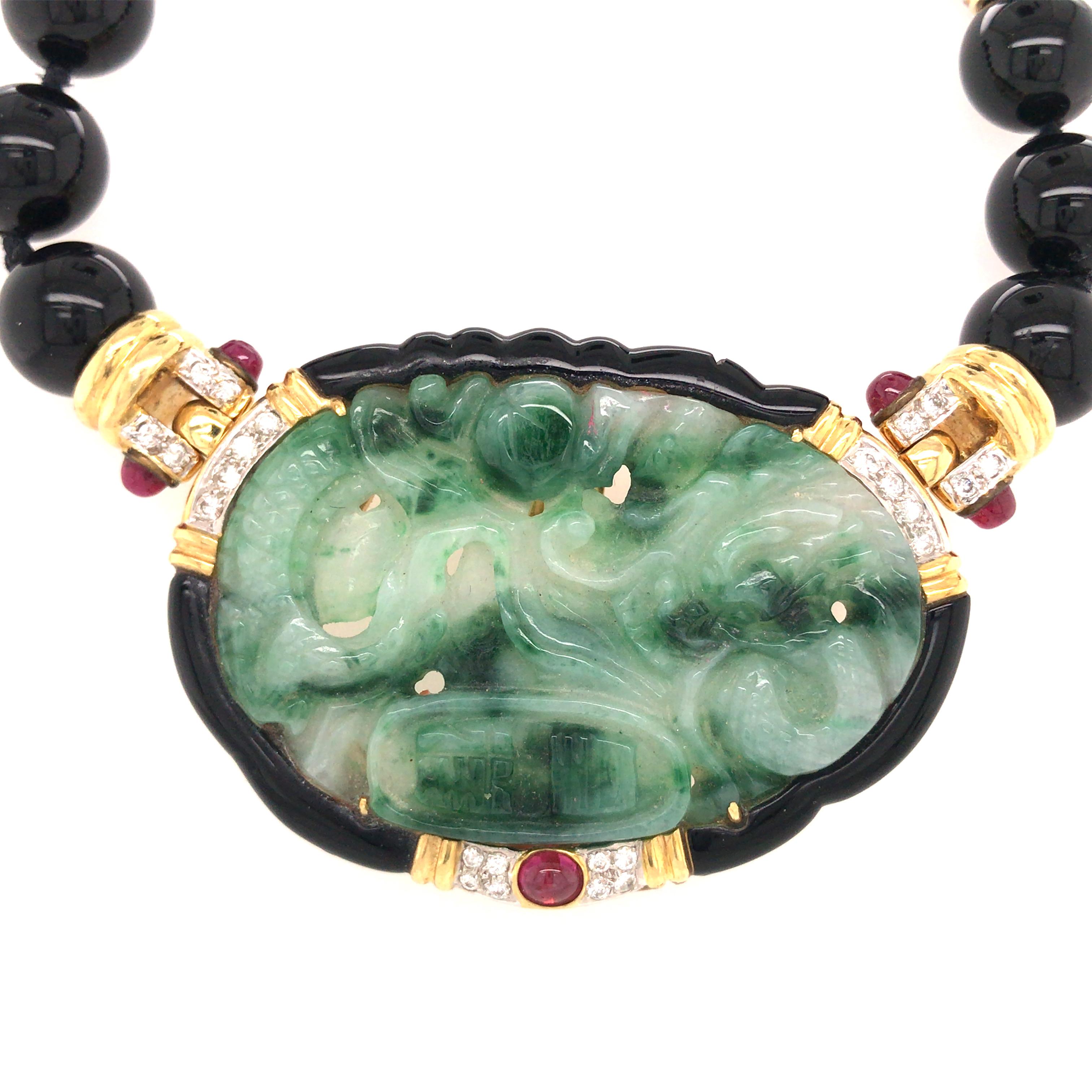 Jade, Ruby, Onyx and Diamond Pin/Enhancer/Necklace in 18K Yellow Gold.  The center oval Jade piece can be removed and worn as a Pin or Enhancer on another Necklace.  The Pin measures 2 inch in length and 1 1/2 inch in width.  The Necklace measure 14