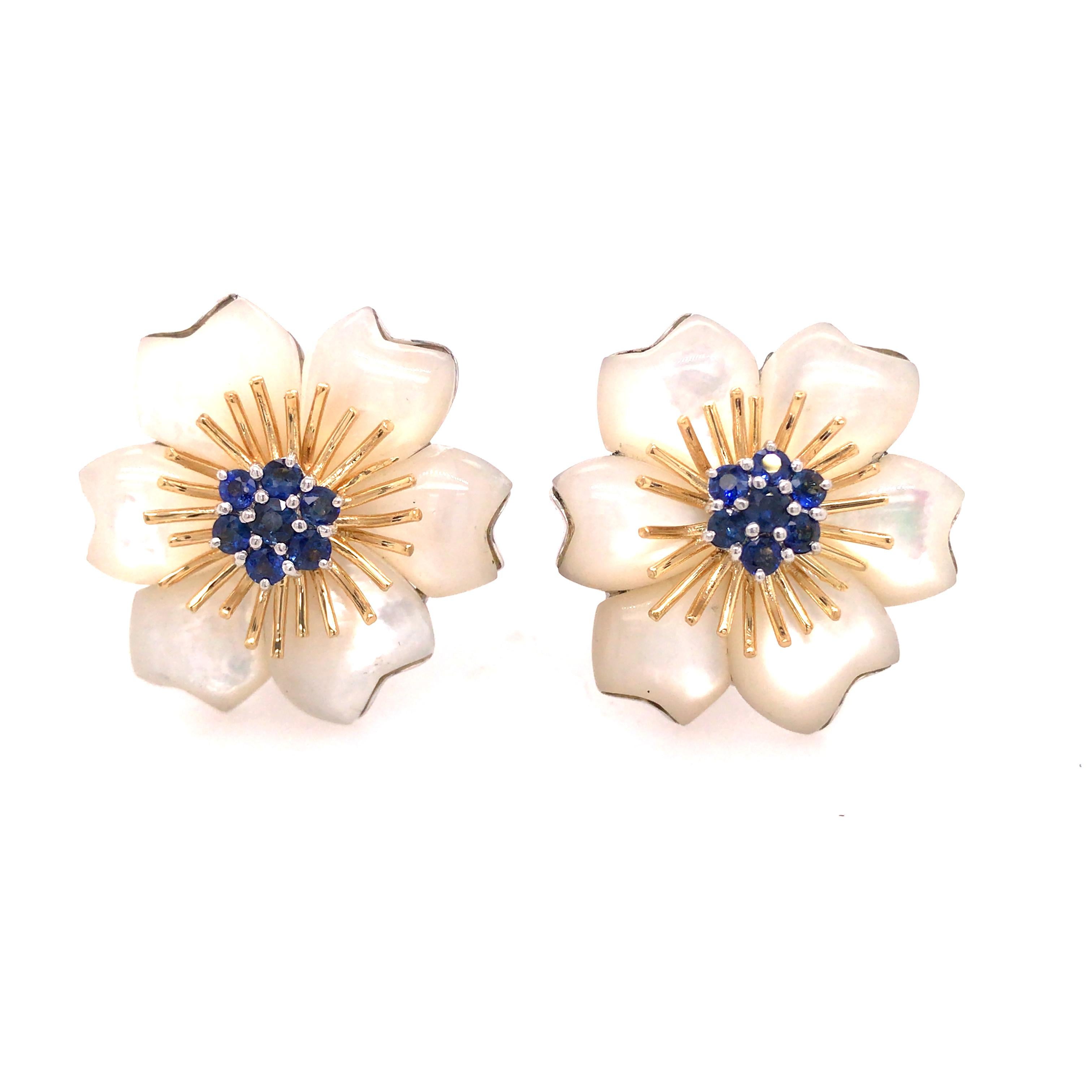 Kanaris Sapphire Flower Earrings in 18K Two-Tone Gold.  (12) White petals with Sapphires weighing 0.70 carat total weight set in clusters as the center of the flower.  18K Yellow Gold accents complete the flowers.  The Earrings measure 1 inch in