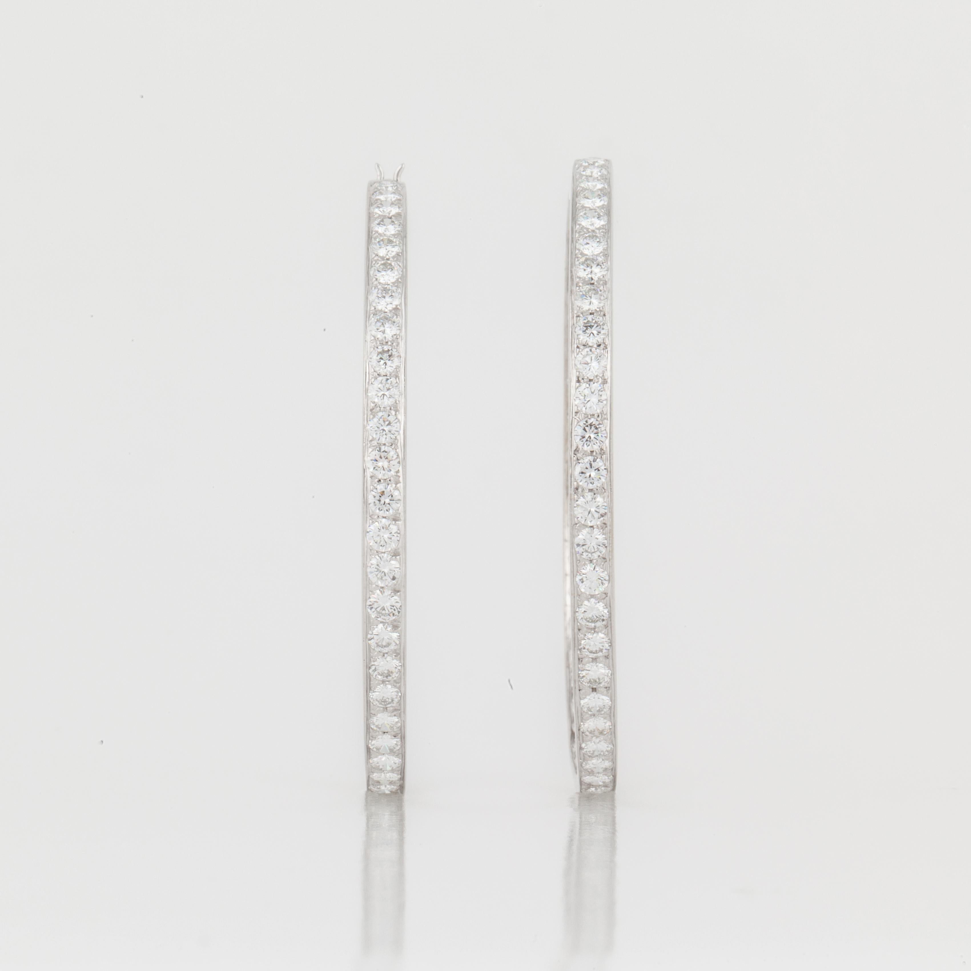 18K white gold inside/outside diamond hoop earrings.  There are a total of 94 round diamonds that total 7.50 carats; F-H color and VVS2-VS1 clarity.  Measure 2 inches in diameter and 1/8 inches wide.  For pierced ears.