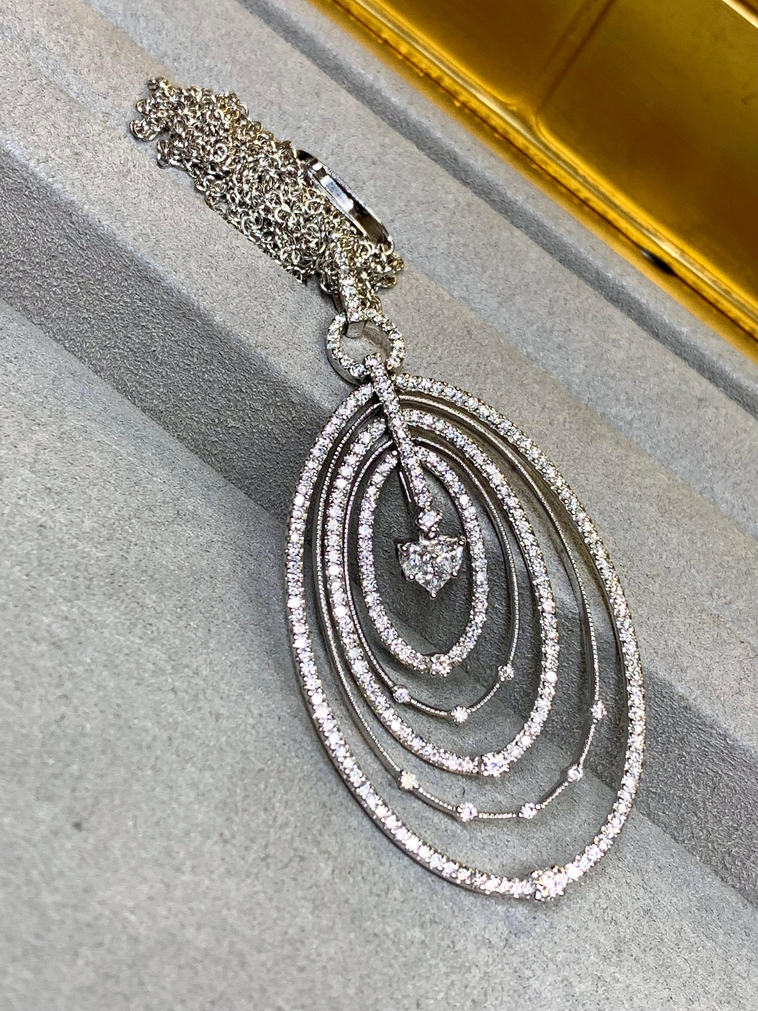 Un pendentif contemporain élégant et bien fait en or blanc 18 carats (la chaîne est en 14 carats) incroyablement bien serti de diamants ronds parfaitement assortis, ainsi que de diamants de taille princesse et de forme poire pour former la partie