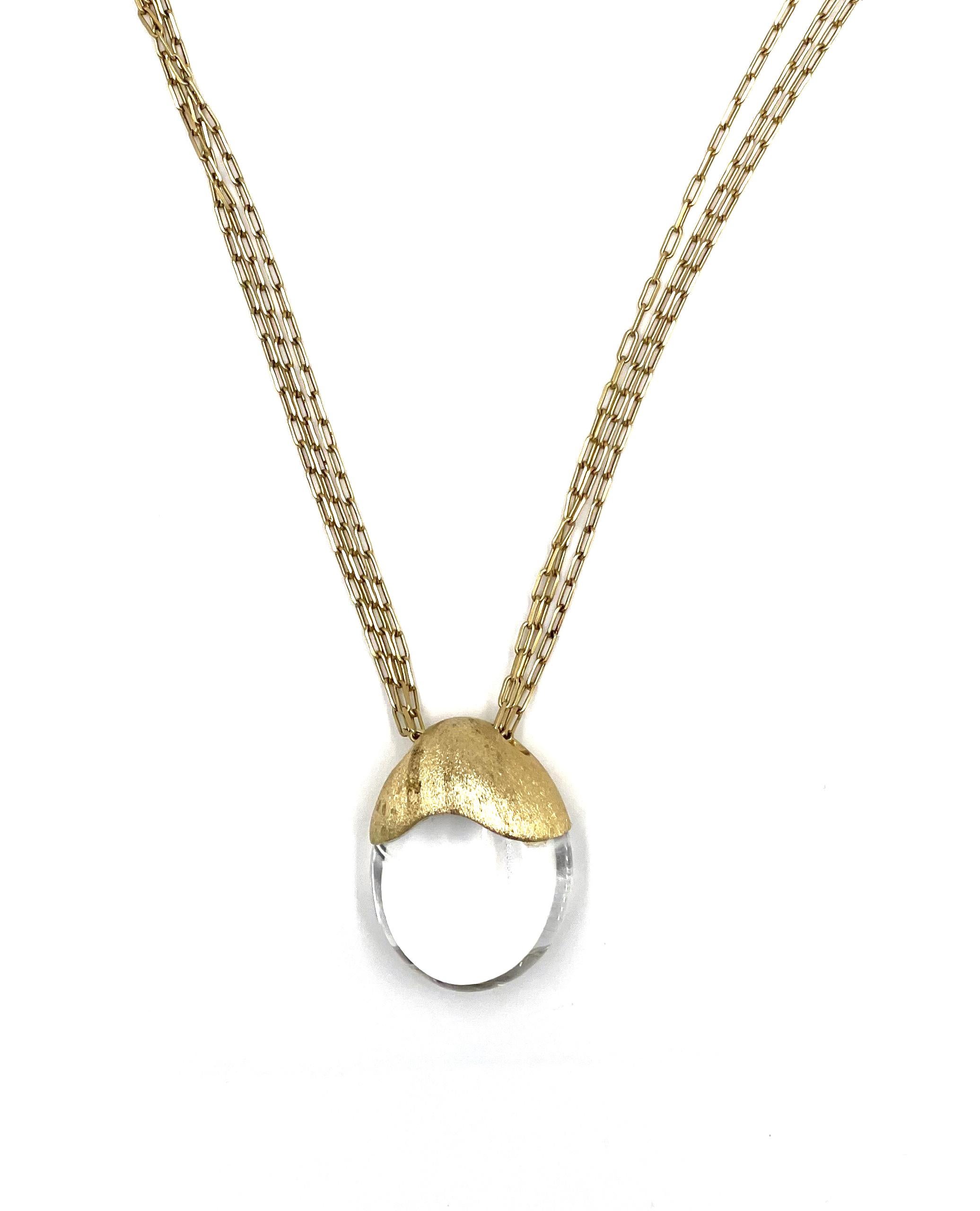 Pre owned vintage estate 18K yellow gold long necklace.  The free form oval shape pendant is decorated with a satin finish and clear crystal quartz. The pendant slides on a 30 inch triple paperclip link chain.  The clasp is a small satin finish