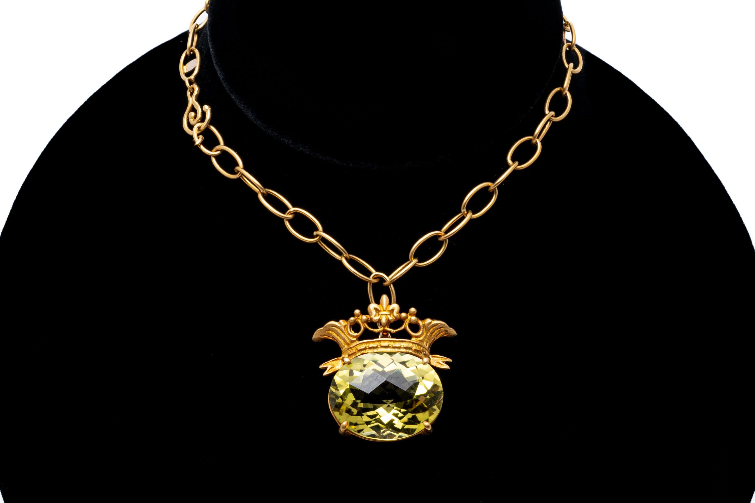 18k and 14k yellow gold necklace. This striking necklace features a matte finished, oval link chain, from which suspends a large, horizontal oval faceted, lemon-lime color citrine, approximately 12.36 CTS, prong set and decorated with a matte