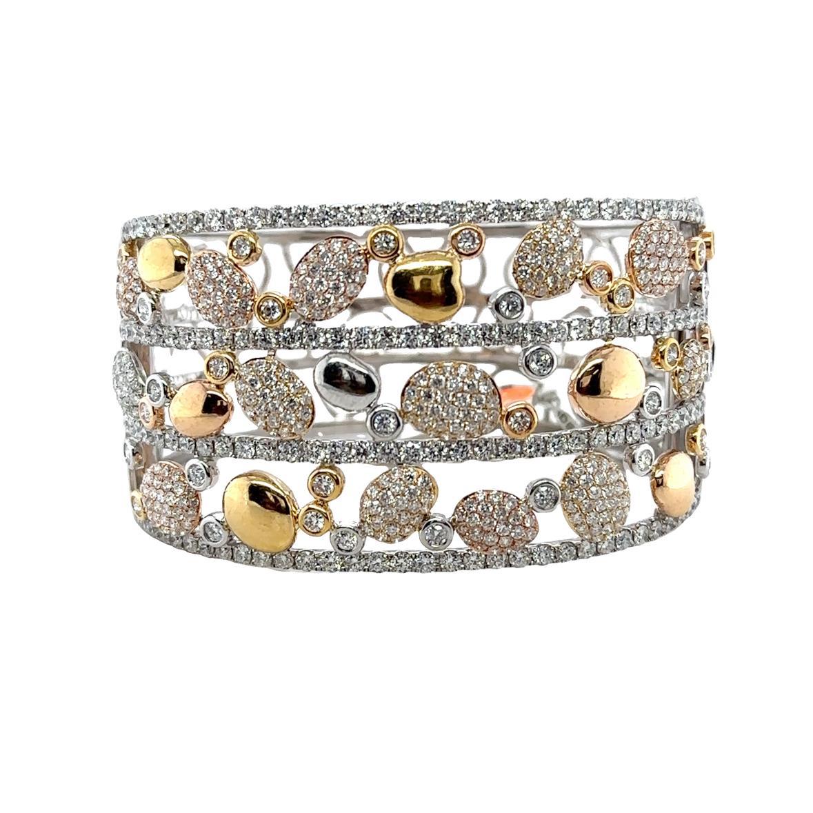 Turn heads with this breathtaking 18K mixed gold wide bangle, masterfully crafted in white, yellow, and rose gold. This luxurious statement piece features an artistic display of polished gold nuggets with pave diamonds and bezel setting with