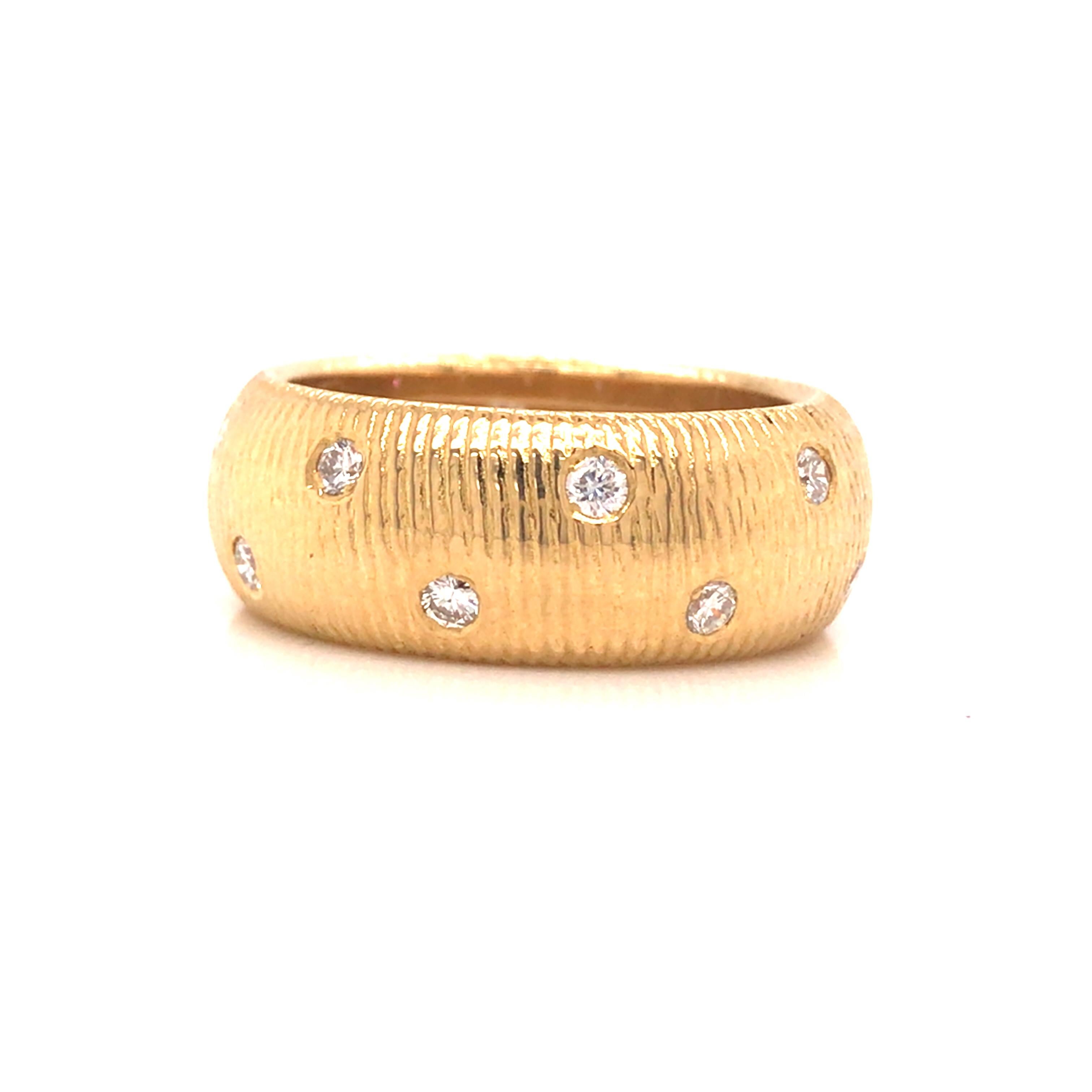 Morelli Textured Diamond Band in 18K Yellow Gold. (16) Round Brilliant Cut Diamonds weighing 0.80 carat total weight, G-H in color and VS in clarity are expertly bevel set. The ring measures 3/8 inch in width.   Ring size 8 1/2. 10.57 grams. Stamped