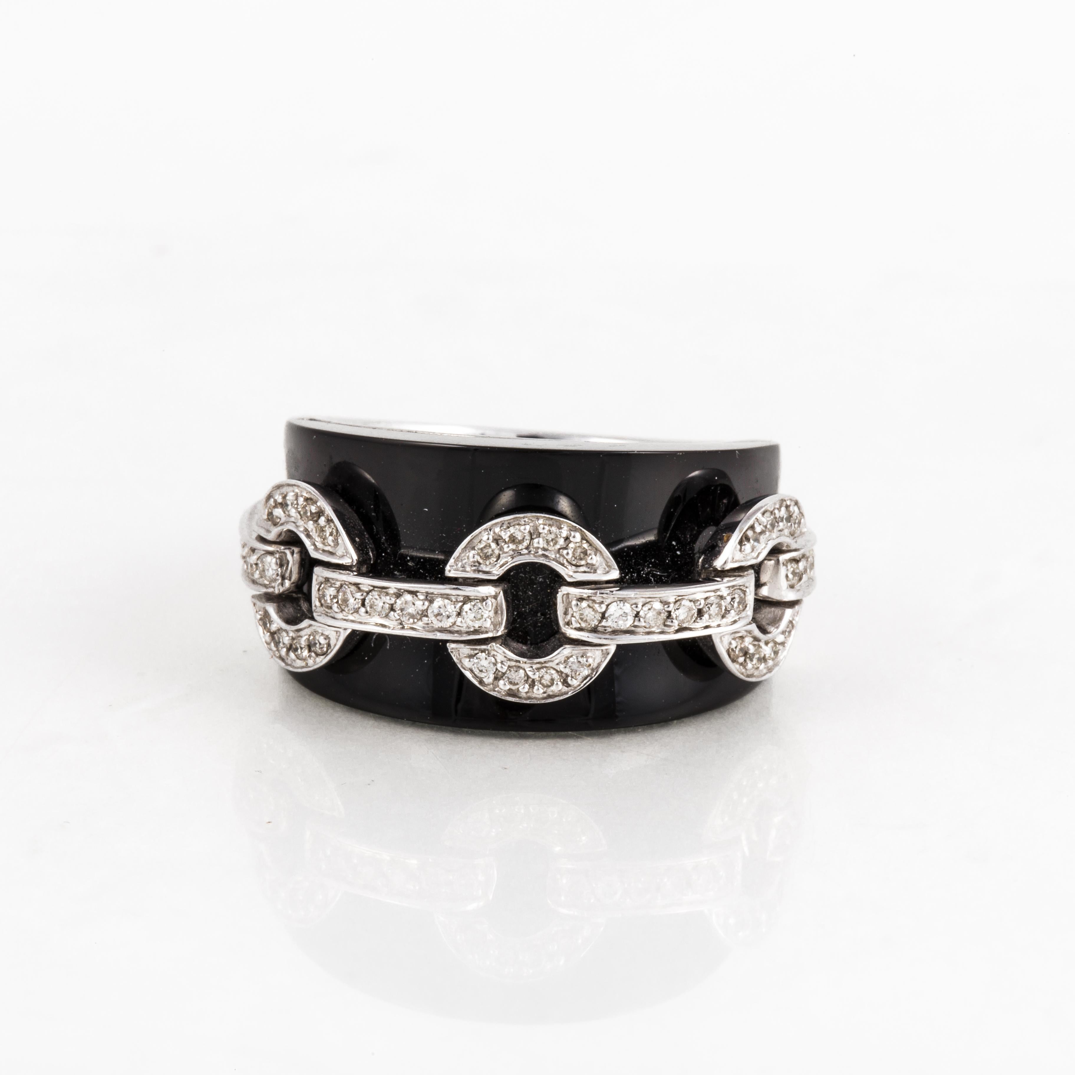18K white gold cigar band style ring with black onyx and diamonds.  The onyx is curved and is accented by 46 round diamonds in a circle link design.  Diamonds total 0.50 carats. Measures 7/8 inches by 3/8 inches.