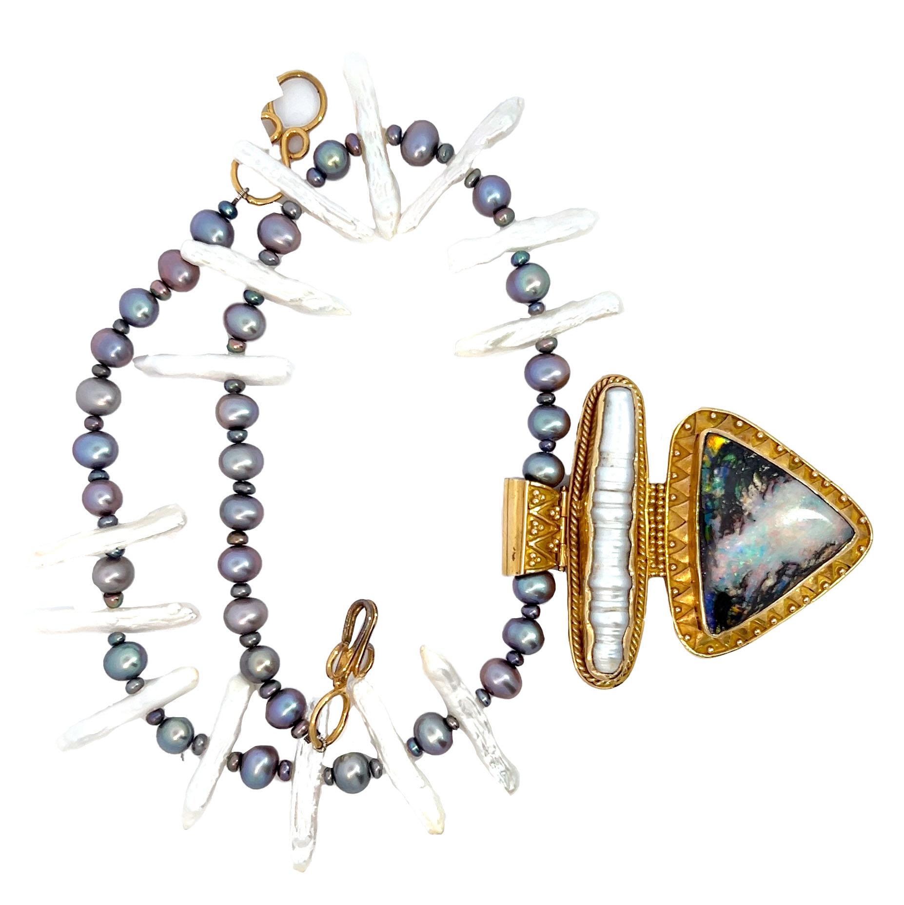 This necklace features elongated white Biwa stick pearls paired with iridescent black peacock pearls, creating a striking contrast of shapes and colors.

The centerpiece is an opalized wood pendant set in 18-karat yellow gold. The pendant, measuring