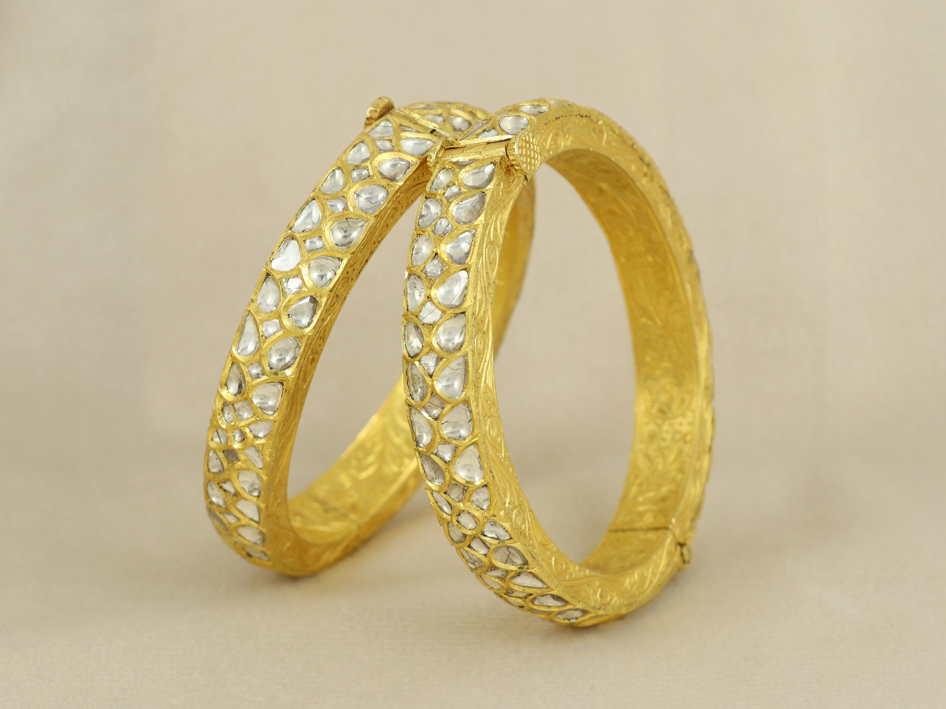 A bangle pair crafted in 18K gold engraved at the back and side, is seated with perfect pear shaped natural uncut diamond polki slices seated with help of 24K gold in kundan technique.


The bangle pair is indian size of 2,3 mana and is slight oval