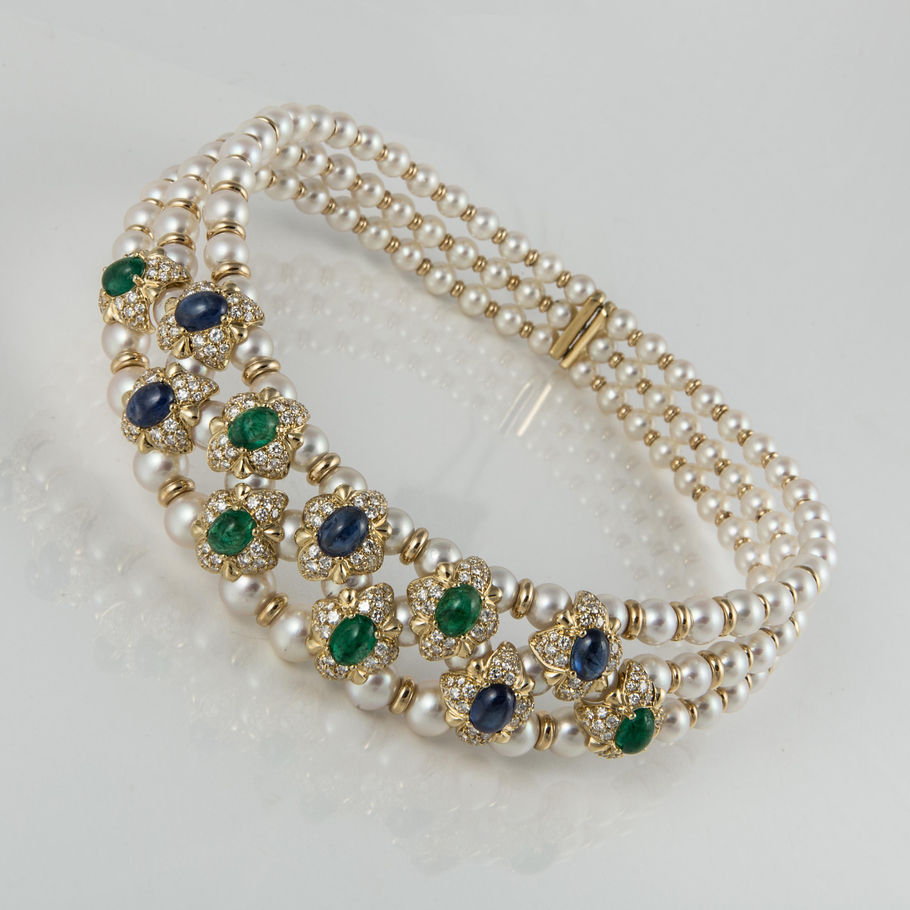 Pearl collar with 132 cultured pearls.  The flower designs contain diamonds, emeralds and sapphires.  There are six cabochon emeralds weighing 12.0 carats.  The six sapphire cabochons total 13.5 carats.  Total of 308 round diamonds weighing 8.0