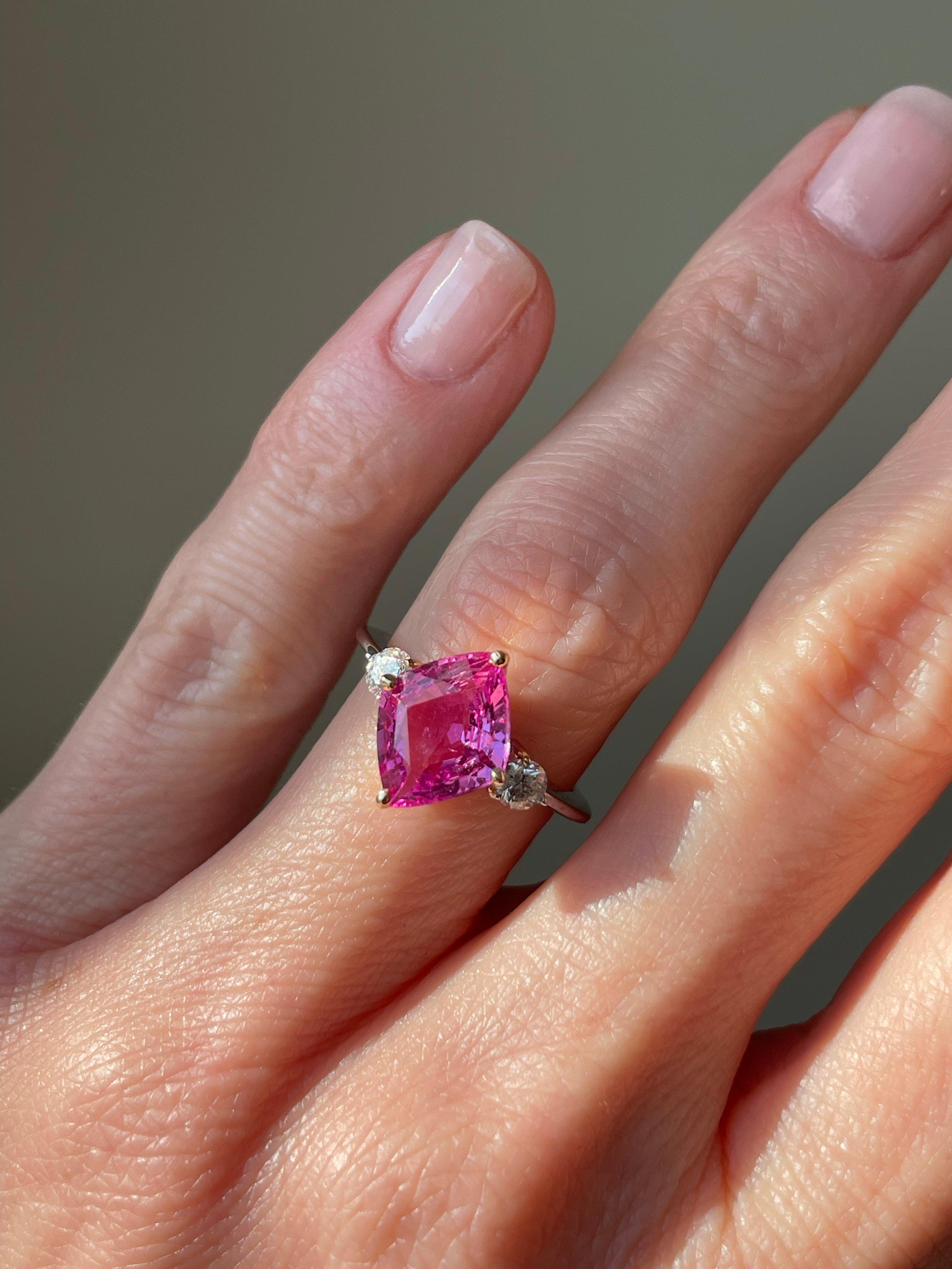 A cheerful bubblegum pink sapphire, weighing 3.29 carats, glows from the center of two bright-white brilliant-cut diamonds. This captivating trio is mounted in 18k rose and white gold. Currently a ring size 6. 

 

Pink sapphire: 3.29 ct, kite