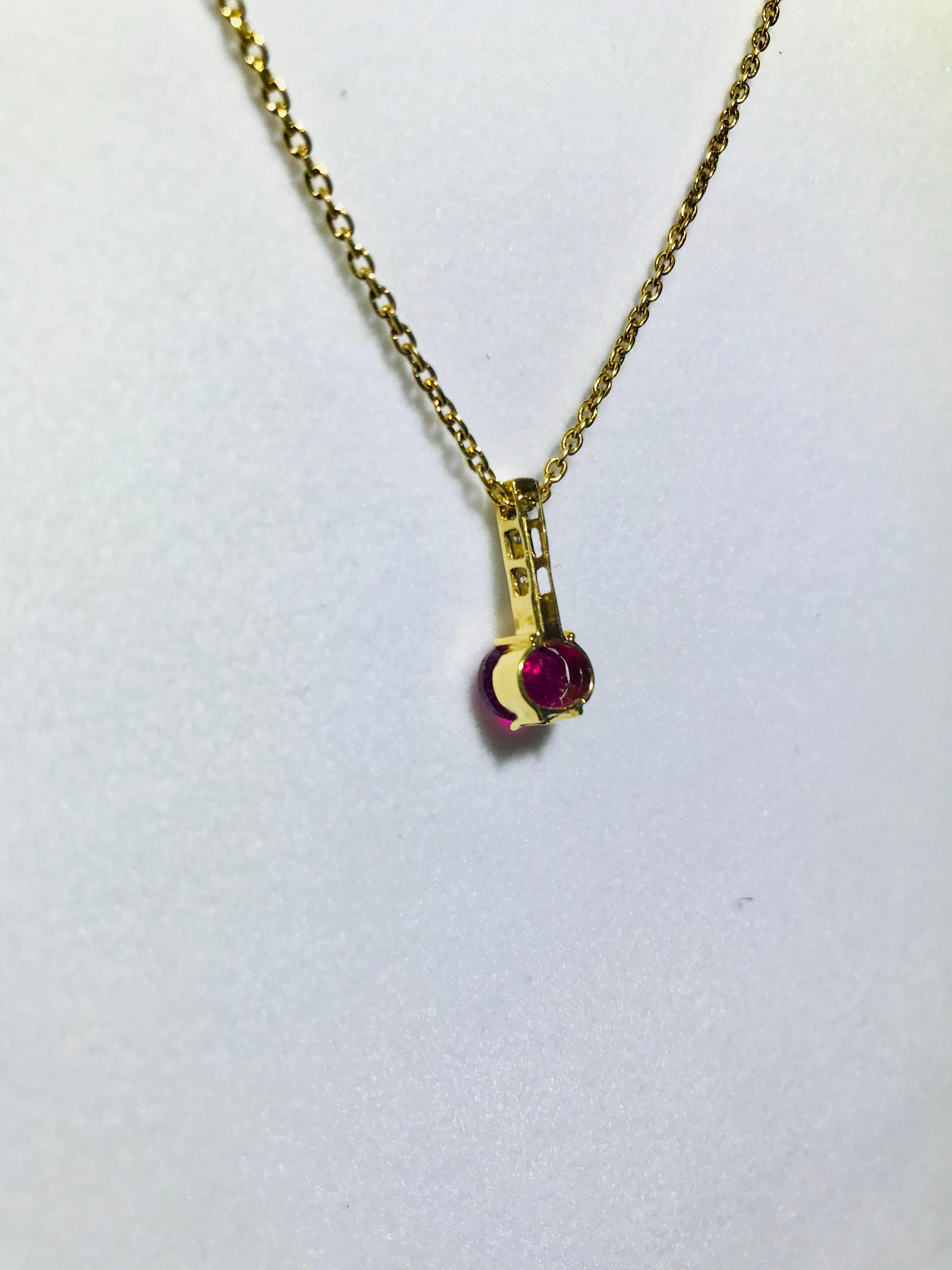 18K yellow gold pendant containing an oval faceted pink tourmaline weighing 1.33 carats and seven accent diamonds weighing combined 0.07 carat.