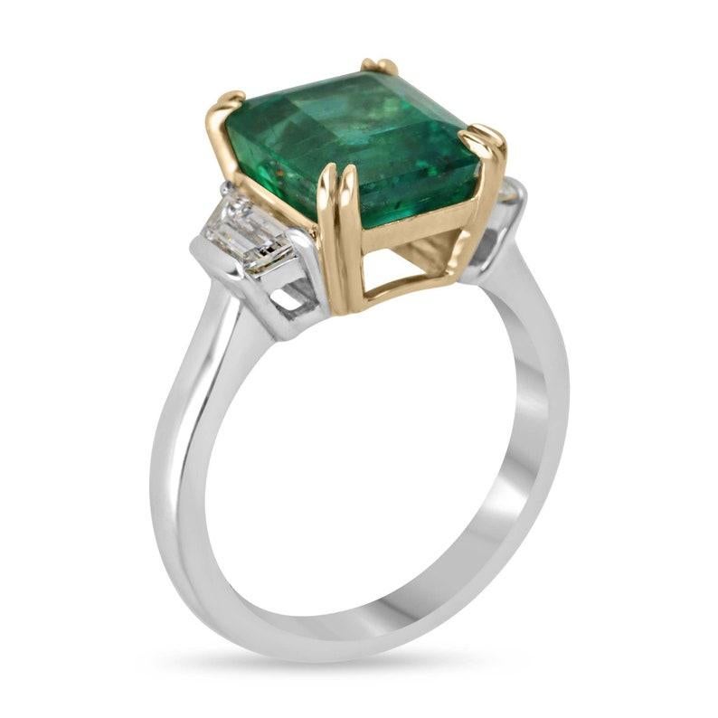 Introducing our stunning emerald and diamond three-stone ring, featuring a captivating 4.49-carat natural asscher cut emerald sourced from Zambia, renowned for its exceptional color, clarity, and luster. Set in an elegant four double-claw prong
